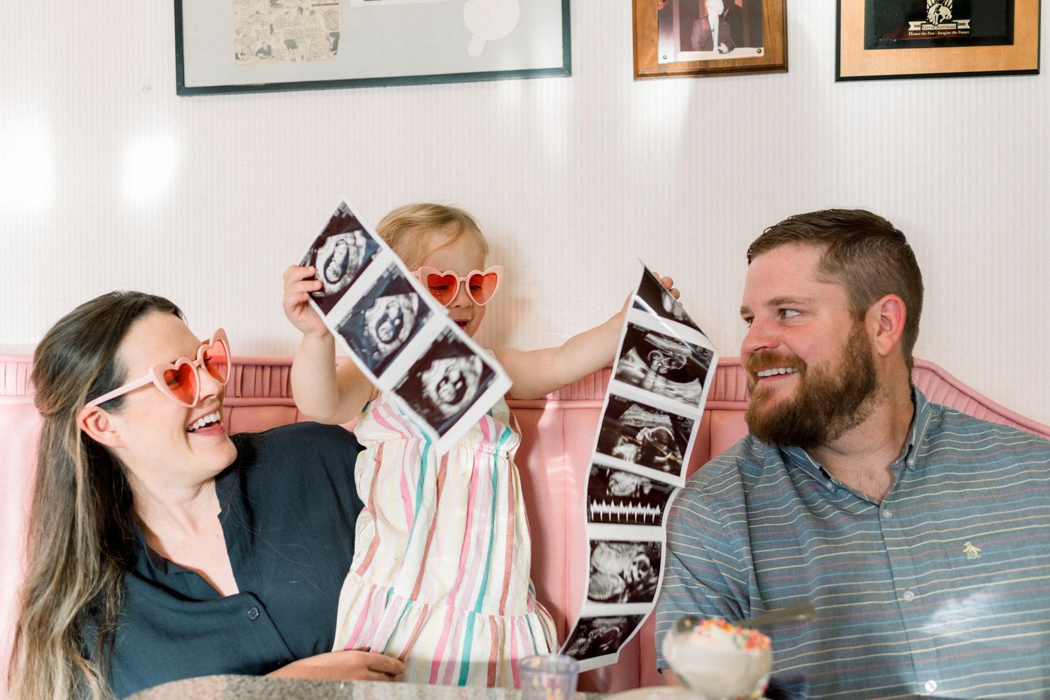 Happy family moment holding and looking at ultrasound photos together.