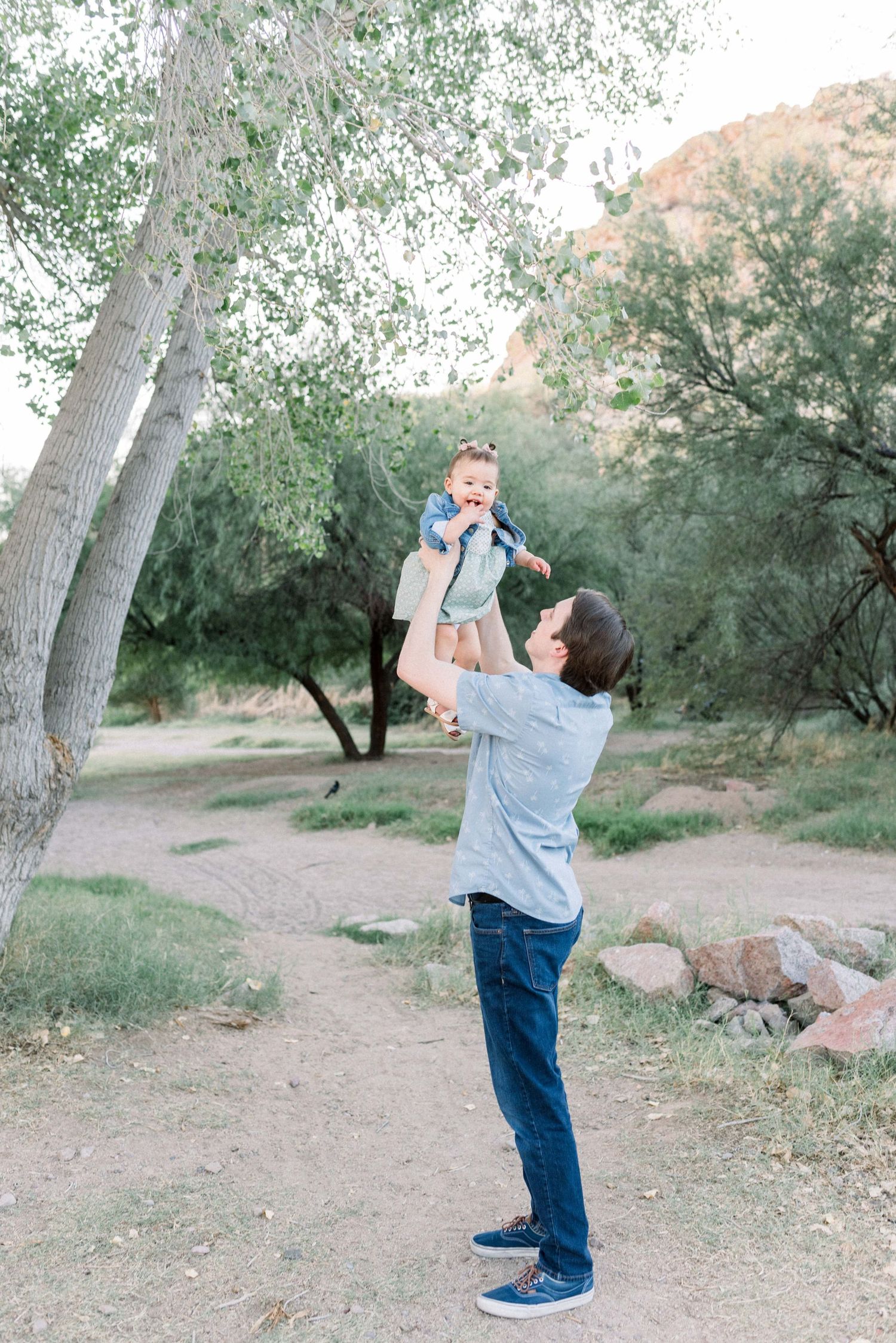 A sequence of four photos showing someone playfully dancing and twirling in a natural outdoor setting with trees and rocks.