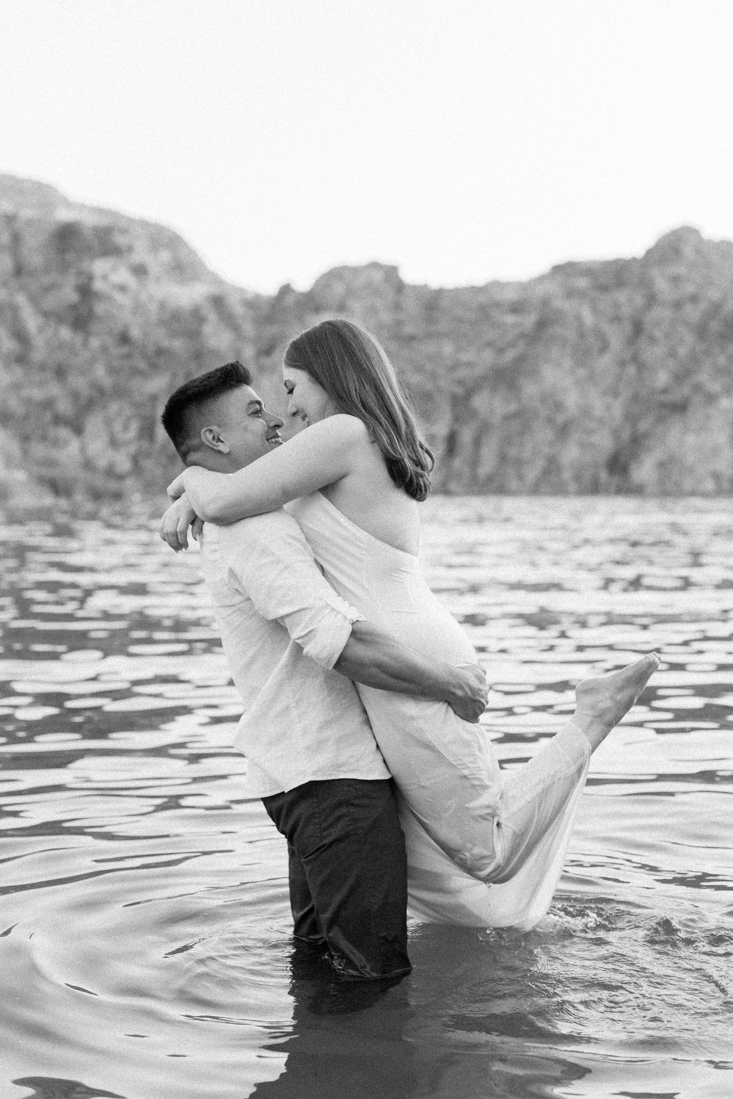 A romantic couple shares intimate moments in a series of black and white photos taken in shallow water.