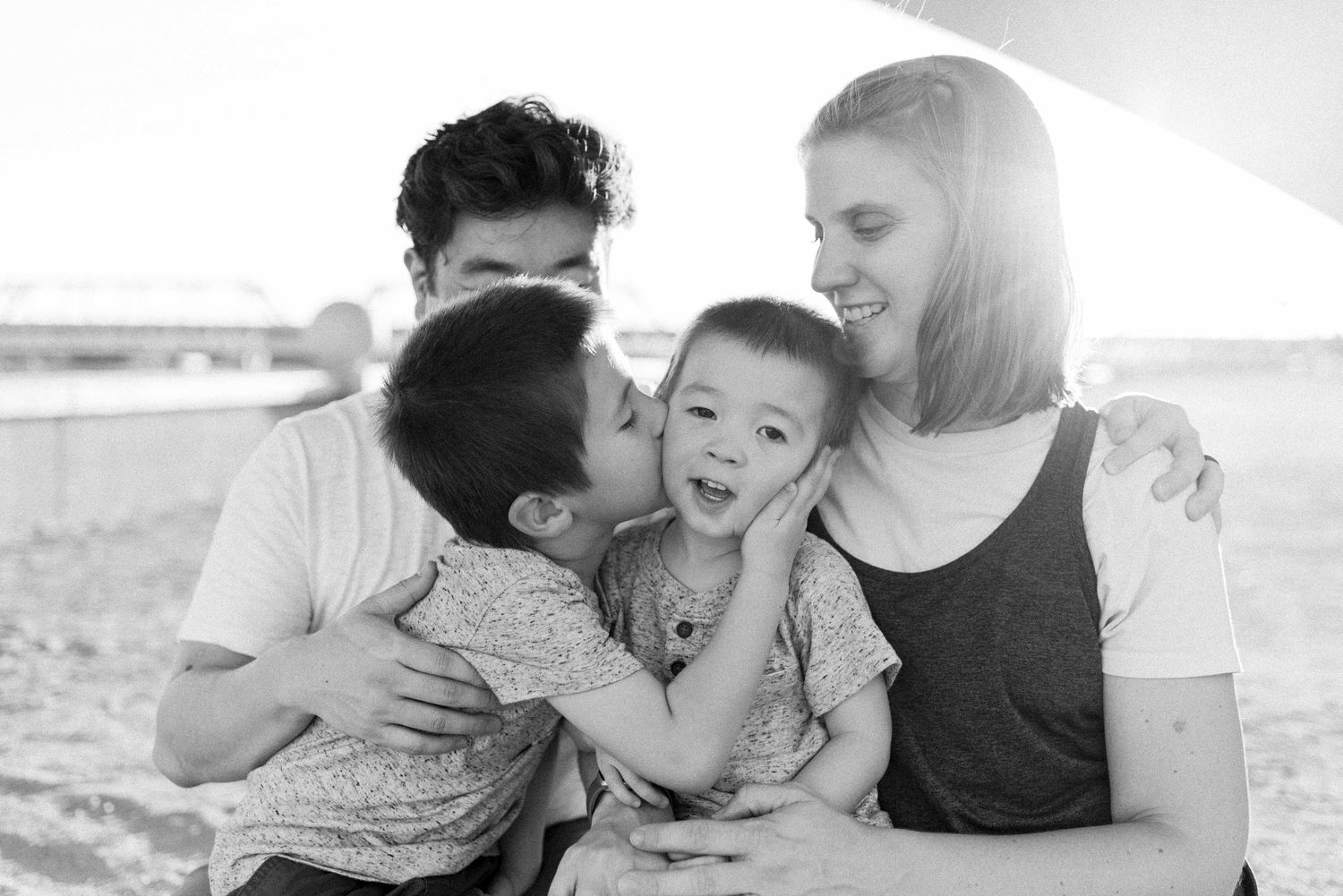 Black and white collage of intimate family moments showing affectionate embraces and tender interactions.