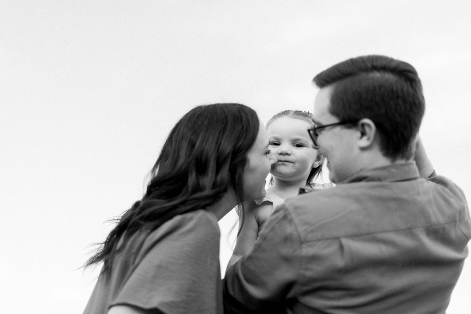 Black and white portrait of family moment in outdoor setting.