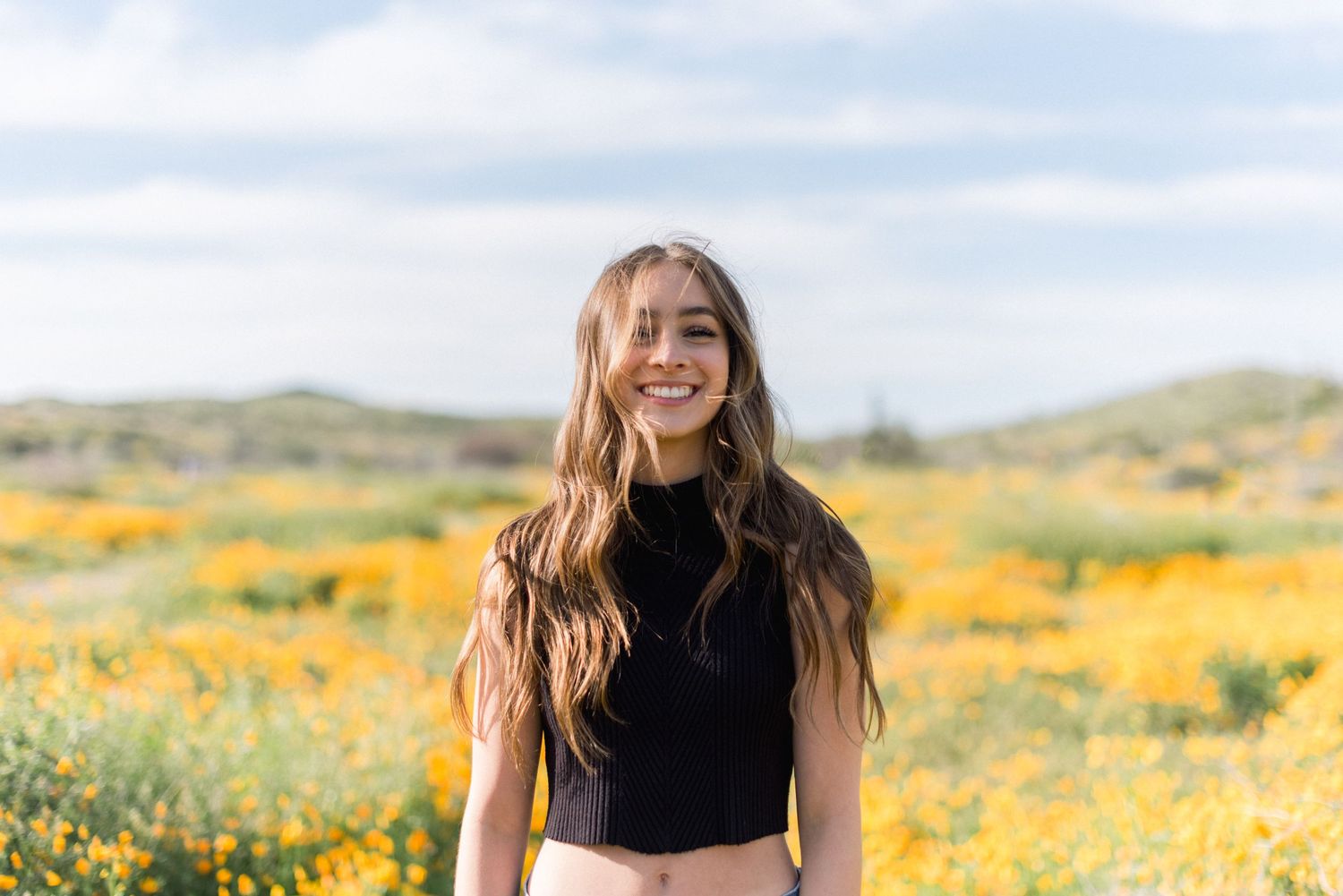A joyful portrait amid a stunning field of yellow wildflowers.