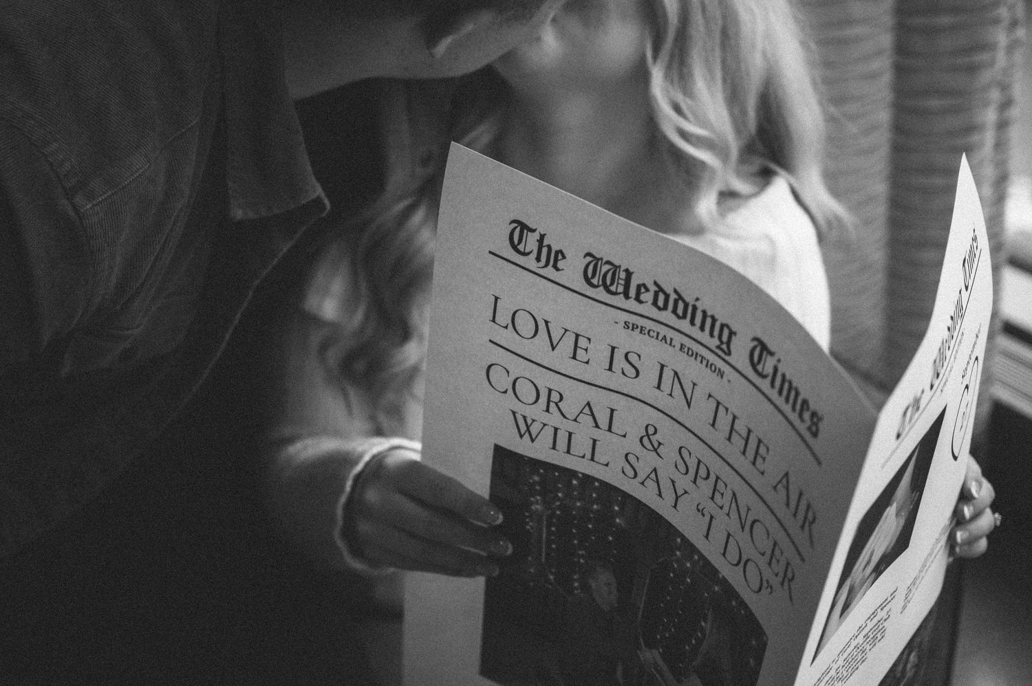 Black and white photo of person reading The Wedding Times newspaper.