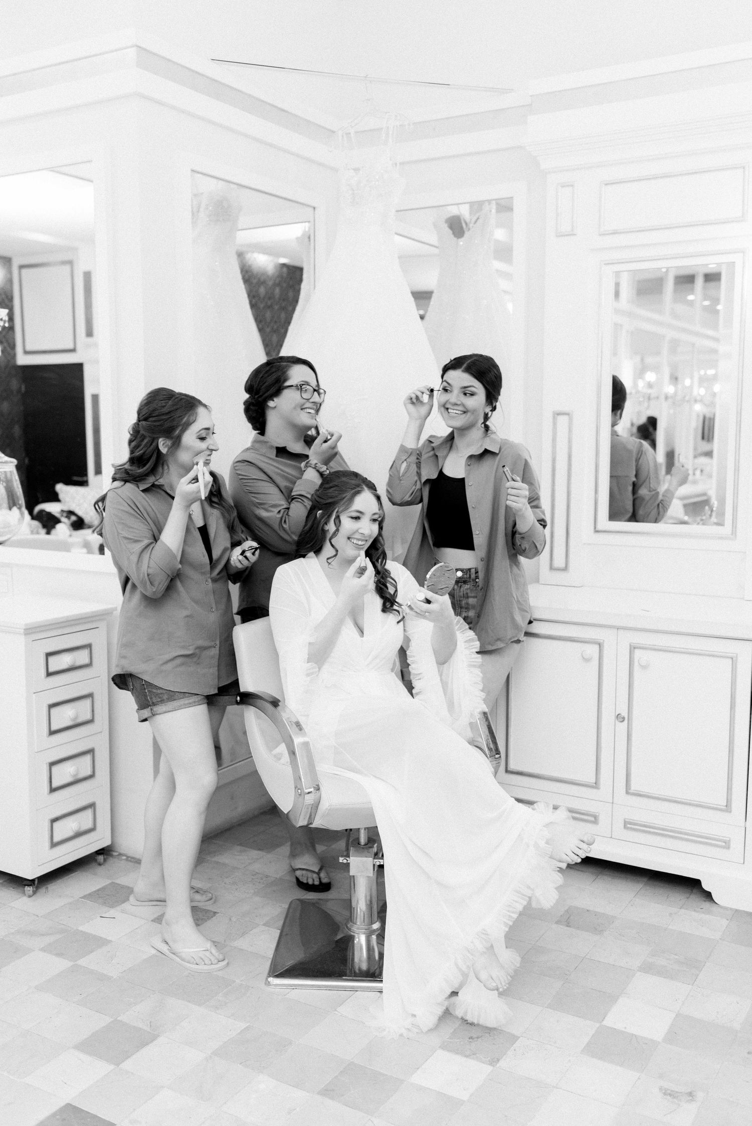 Black and white photo of wedding preparation moment in an elegant dressing room.