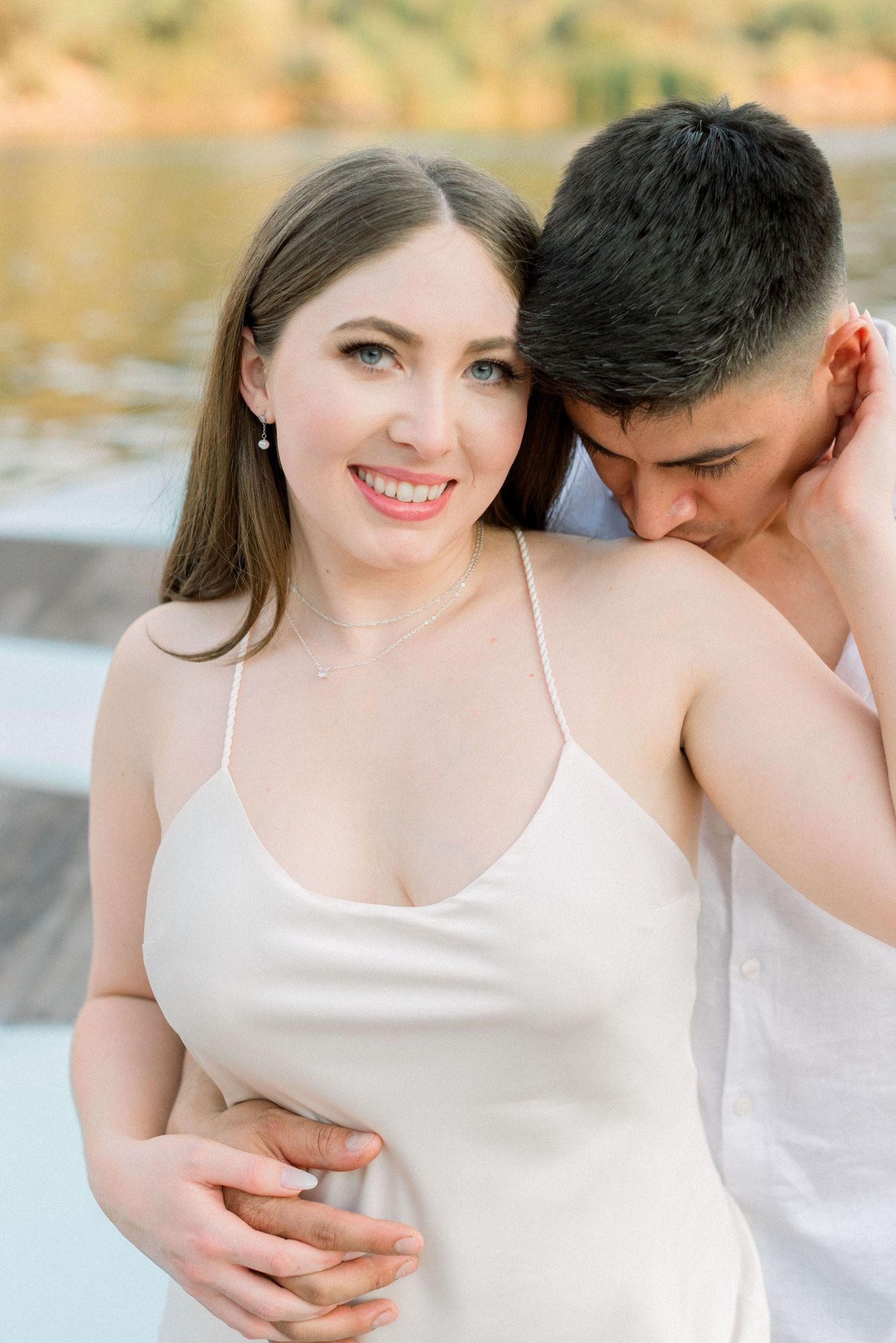 A tender moment captured between a couple during a lakeside photoshoot.