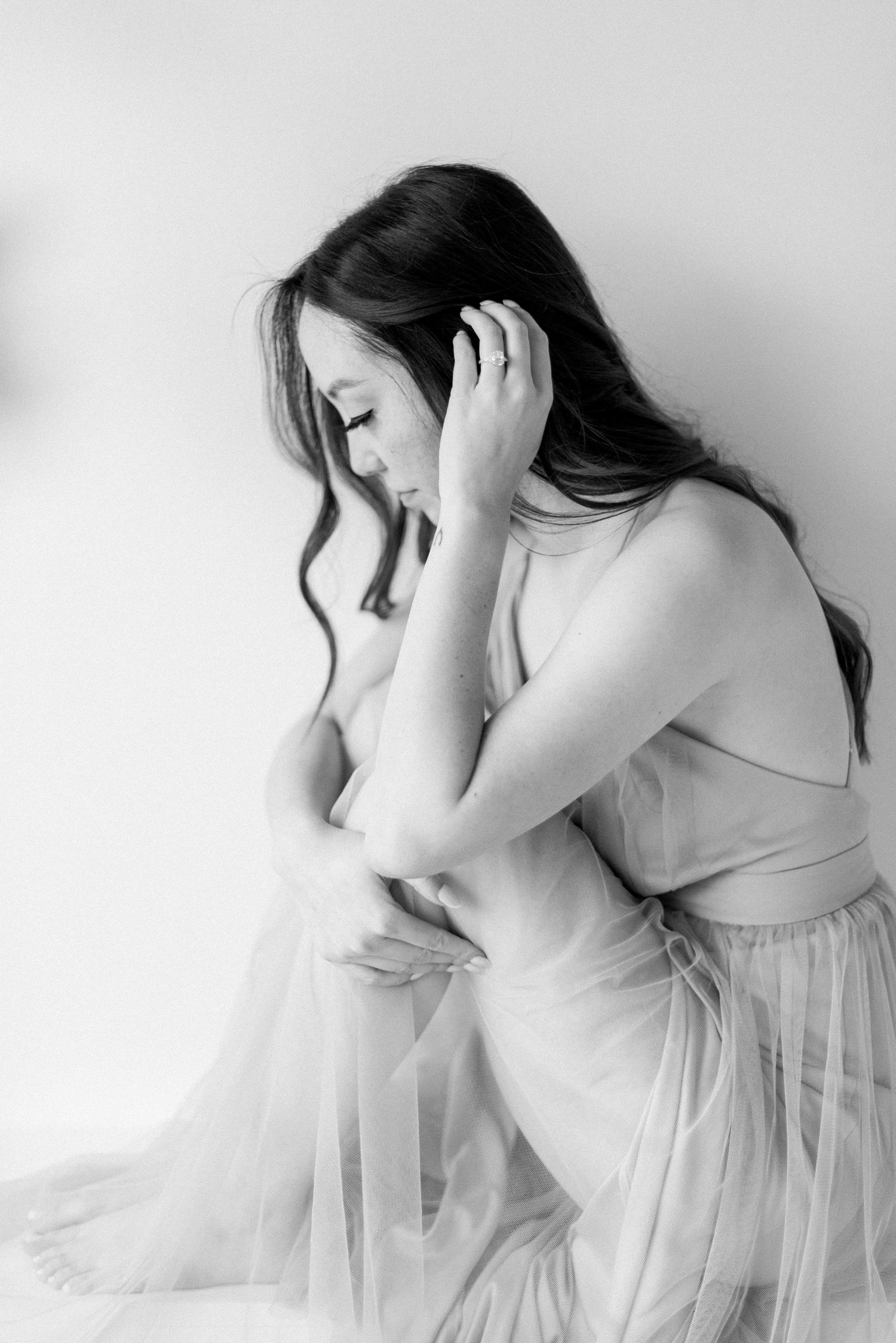 Artistic black and white portrait showing soft movement in delicate tulle dress.
