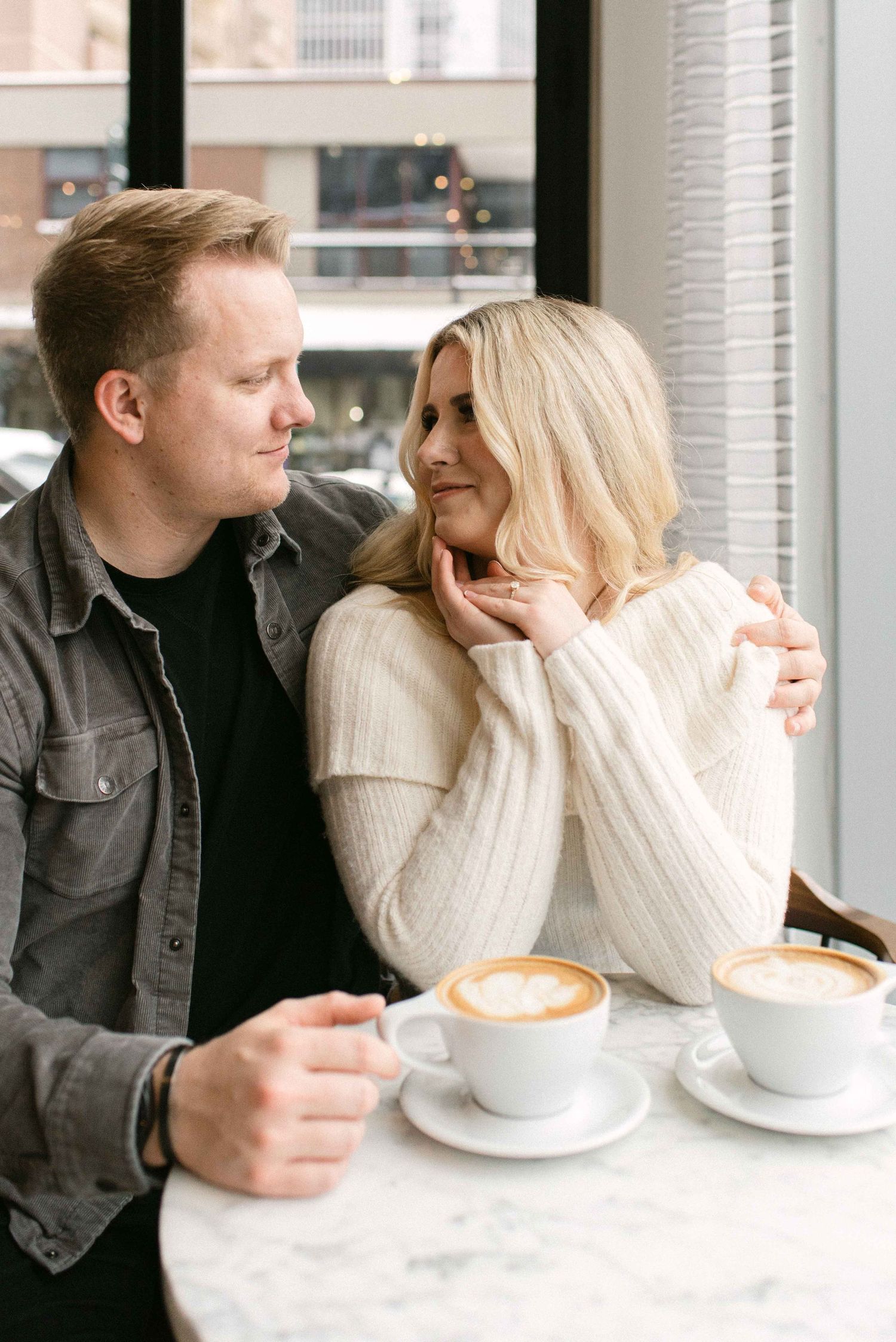 Romantic couple sharing intimate moment over coffee at urban cafe.