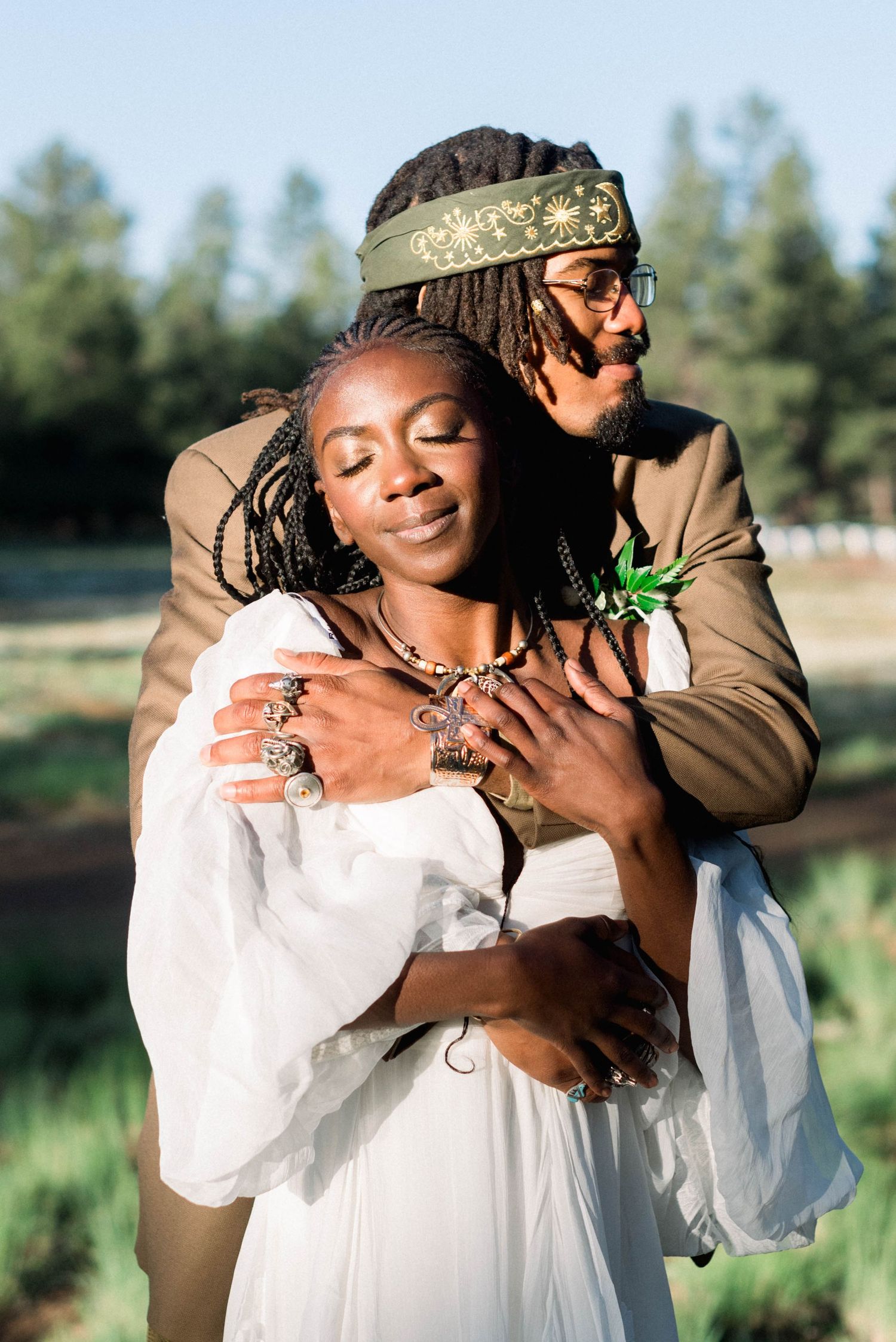 Romantic embrace in a natural outdoor setting with soft afternoon light.