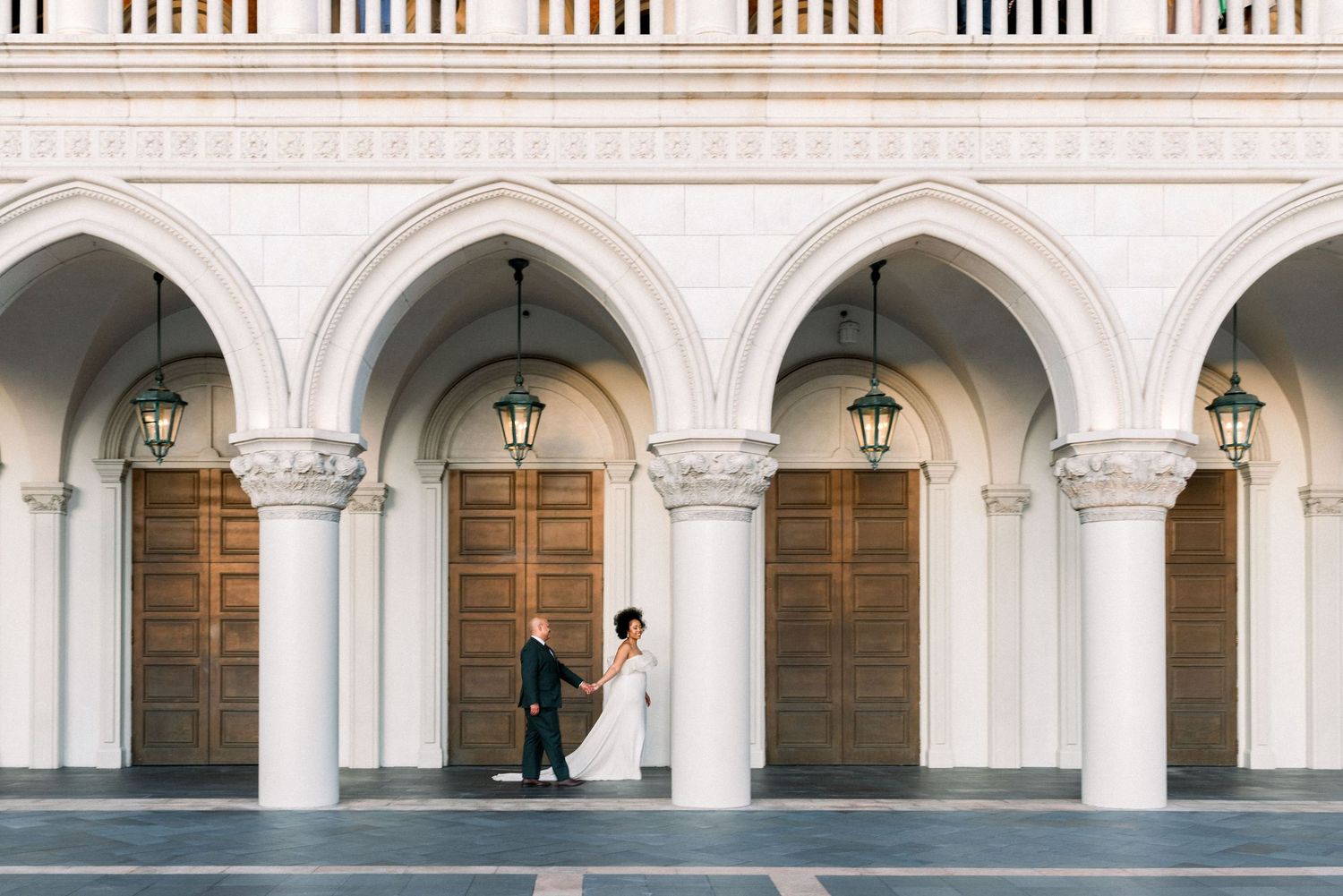 Classical white stone archways and columns along a building exterior.