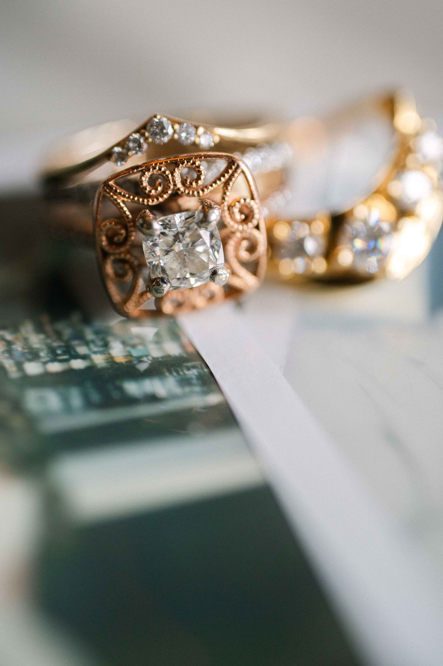 Close-up of an ornate vintage-style gold engagement ring with diamond detailing.