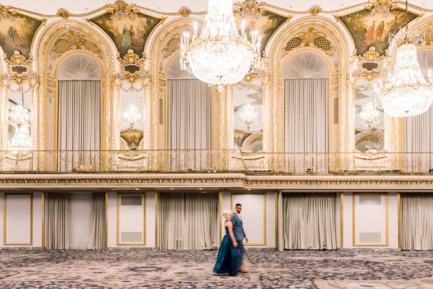 Grand ballroom features ornate gold details and crystal chandeliers.