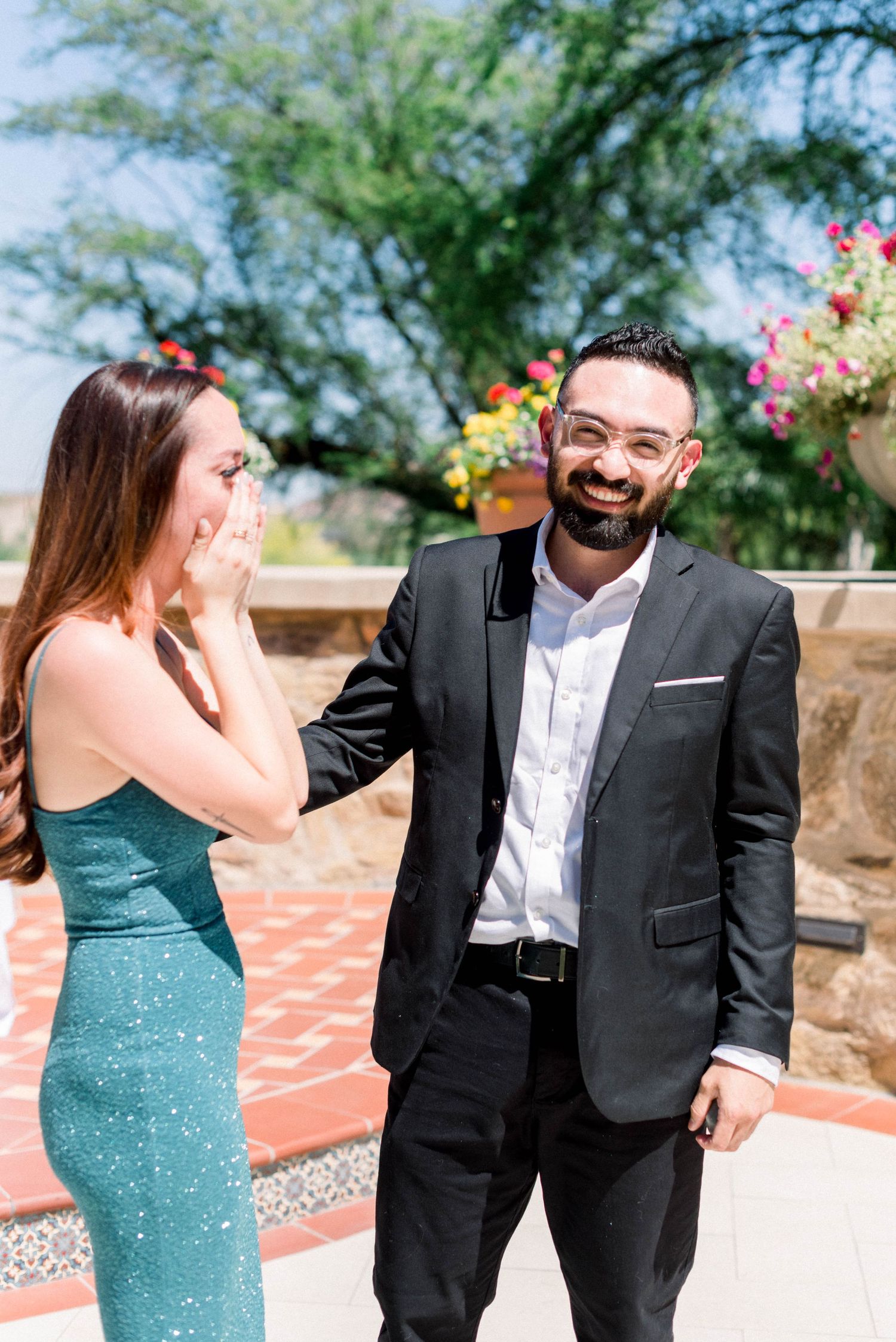 A joyful reaction during a surprise proposal moment on an outdoor patio.