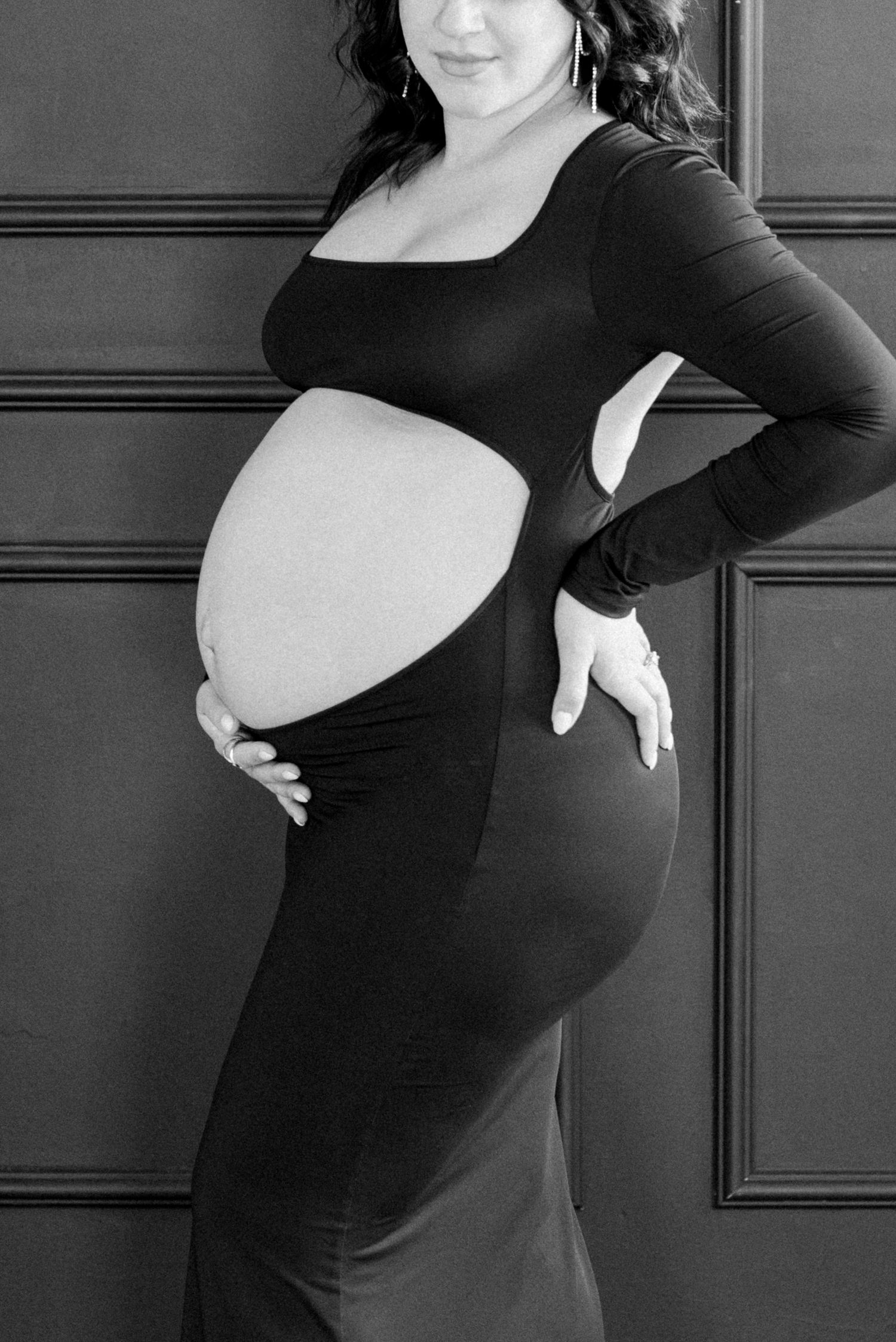 Black and white artistic maternity portrait highlighting pregnancy silhouette.