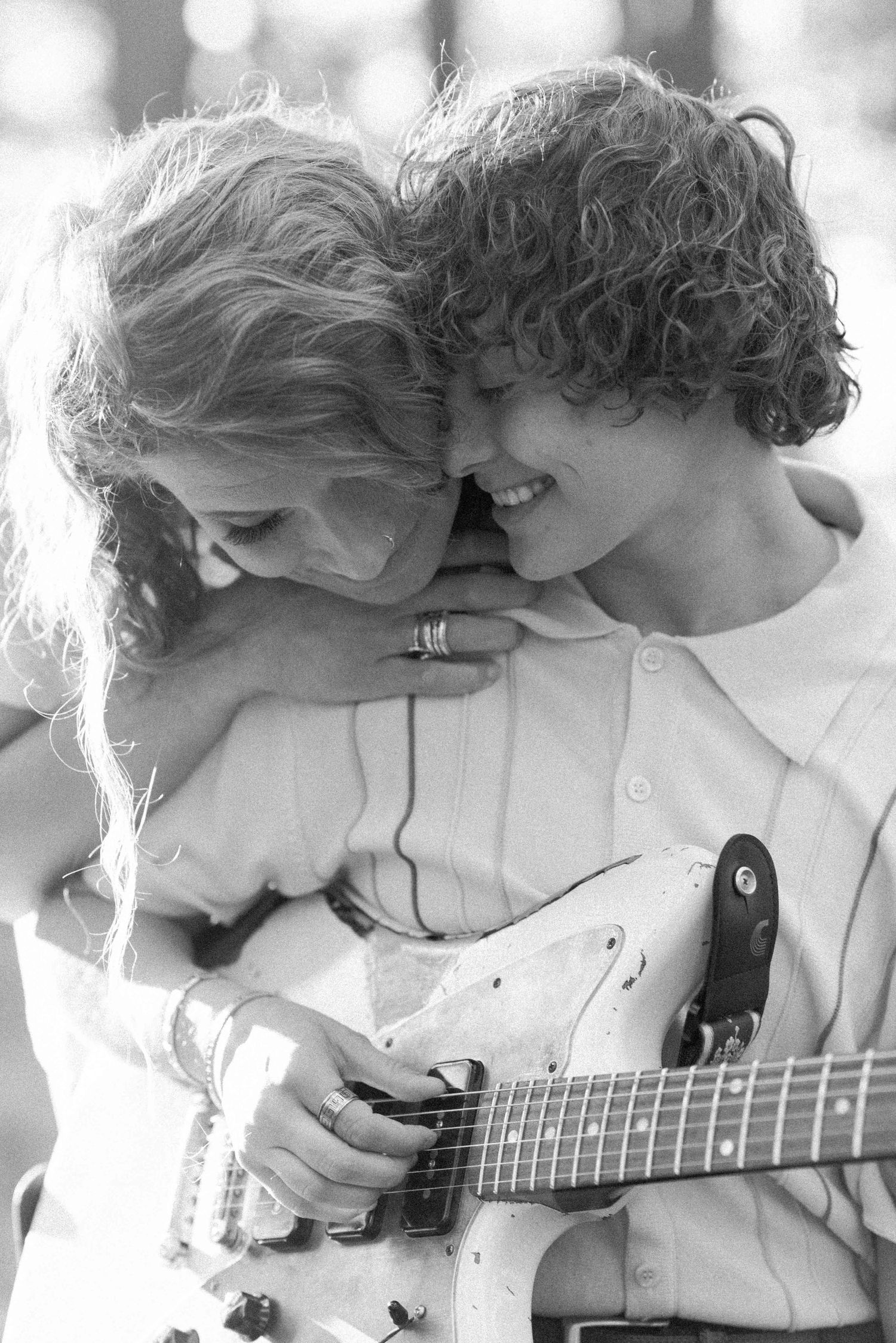 Black and white photo of a couple sharing an intimate moment with an electric guitar.