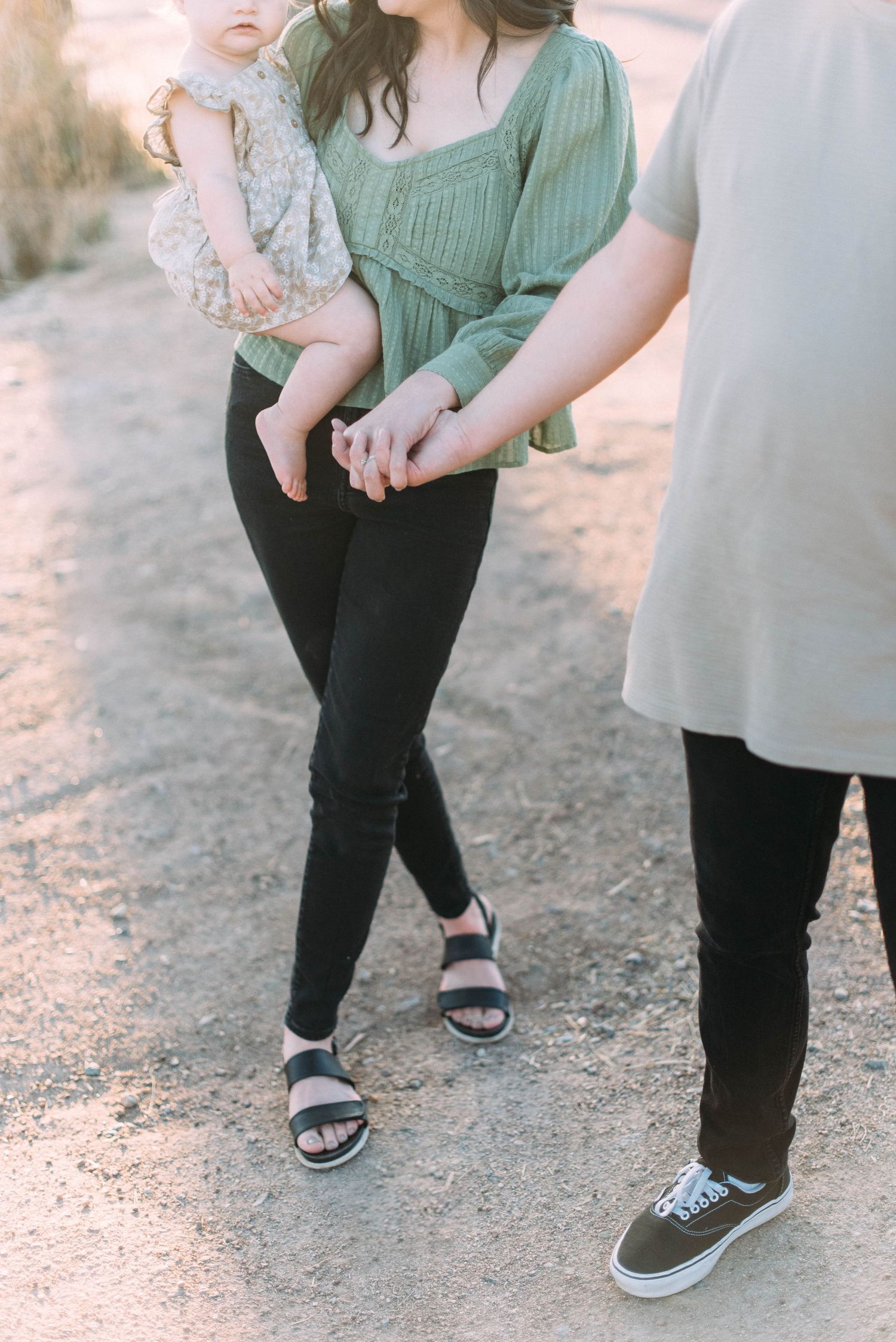 Close up of family's casual attire and footwear while walking on dirt path.
