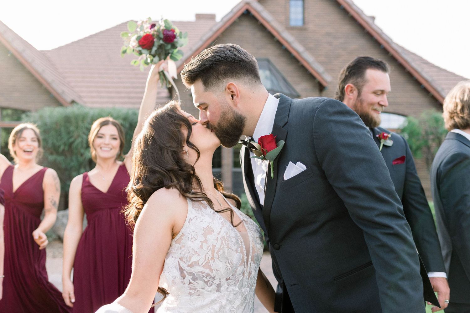 Wedding party celebrates and laughs together outside during formal photos.