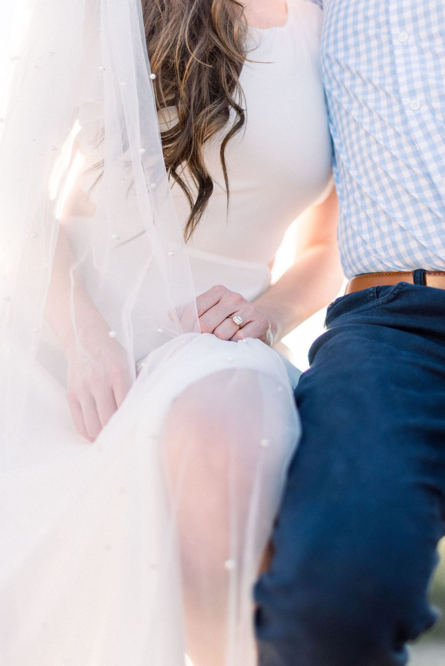 Artistic close-up photo showing white fabric and blue gingham details in soft lighting.