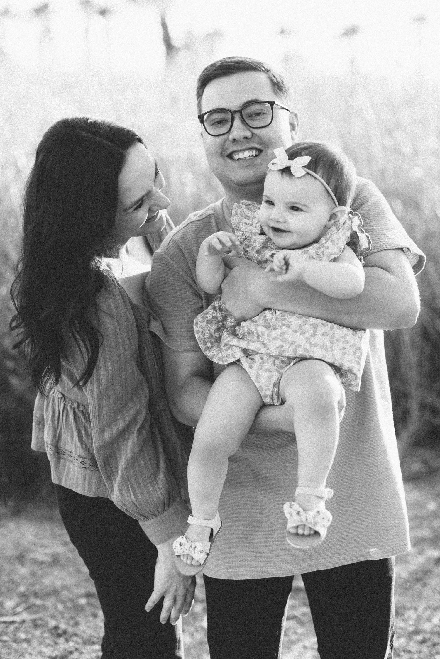 Black and white family portrait outdoors with joyful expressions.