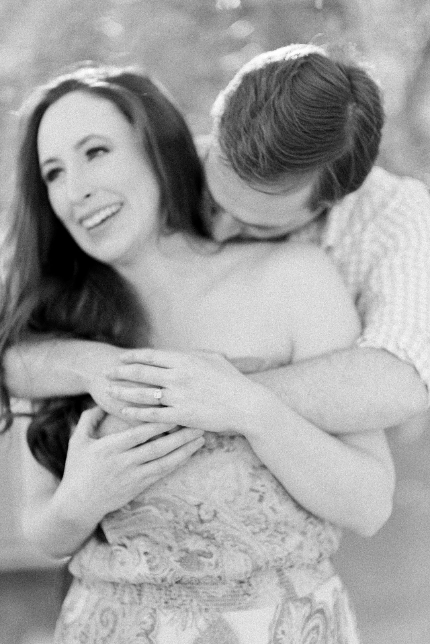 Black and white intimate portrait of couple sharing tender moment outdoors.