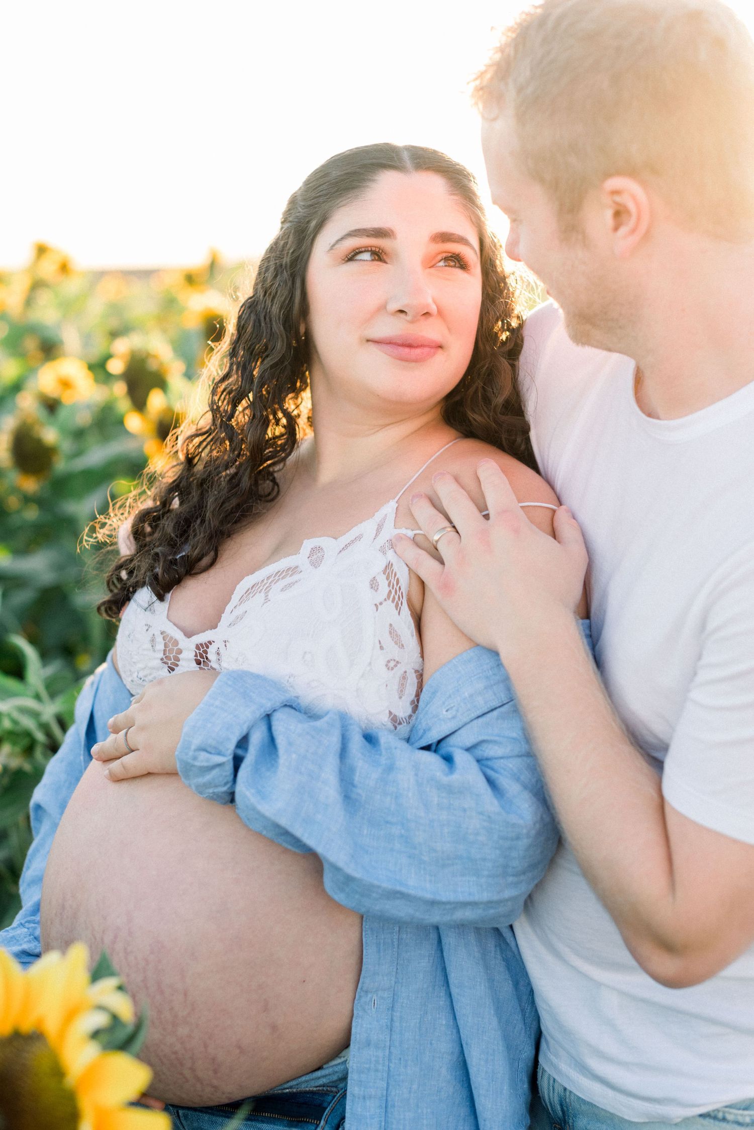 Maternity photo of couple in sunflower field