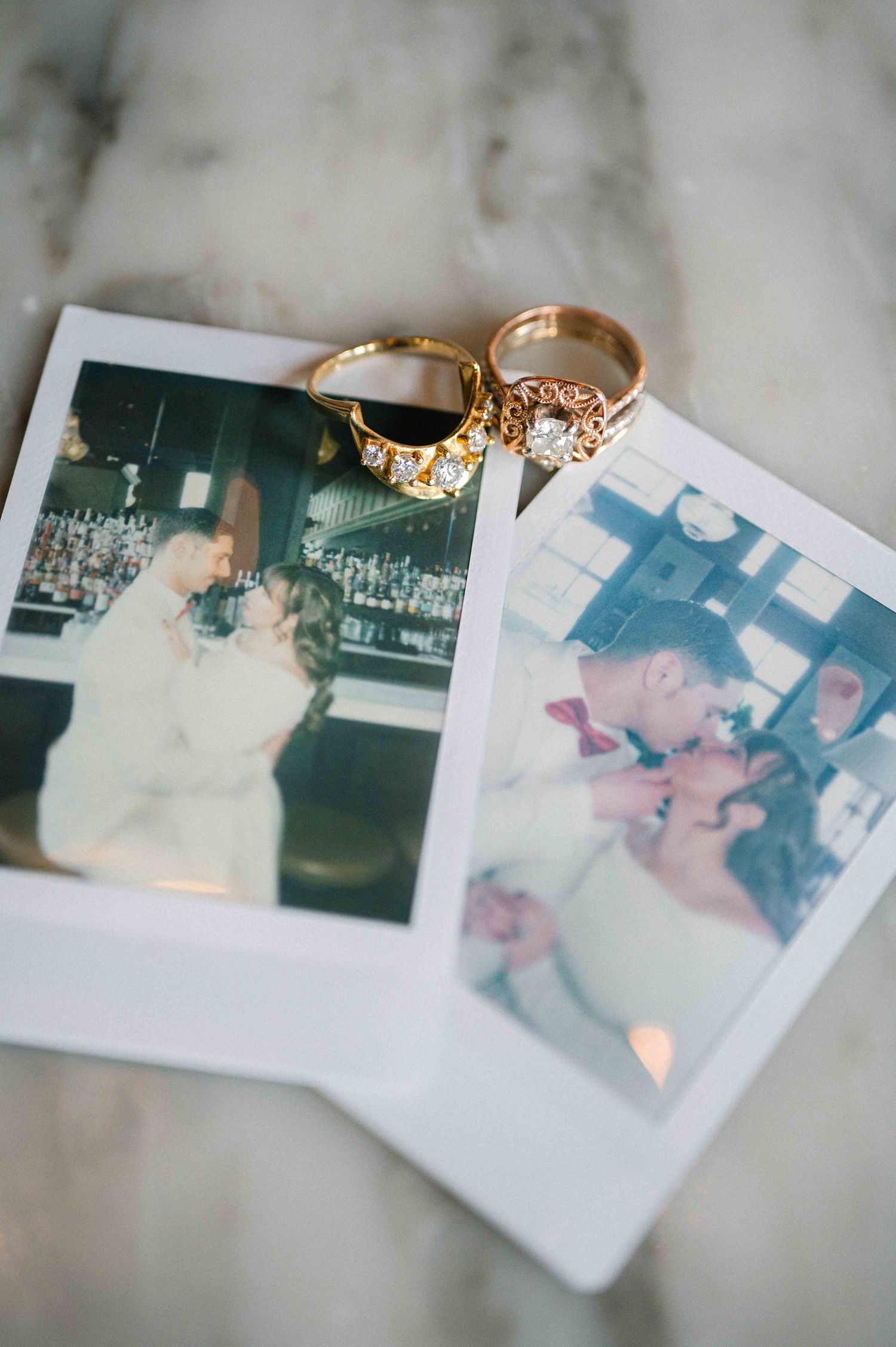 Wedding rings displayed on polaroid photos capturing romantic moments.