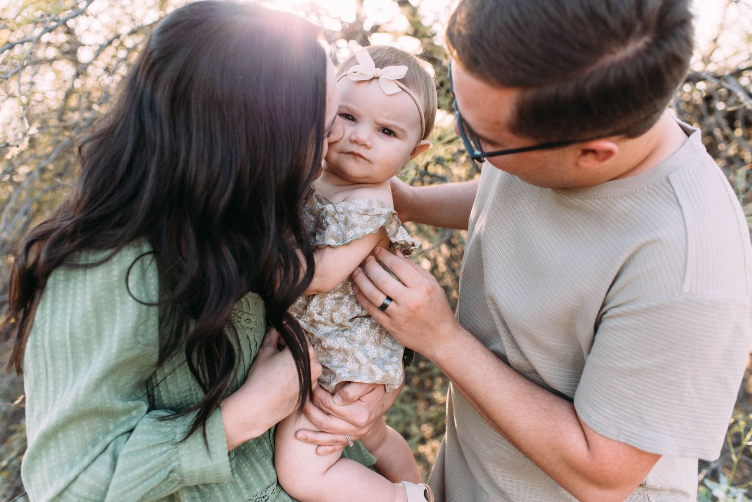 Family shares tender moment together outdoors during sunset.
