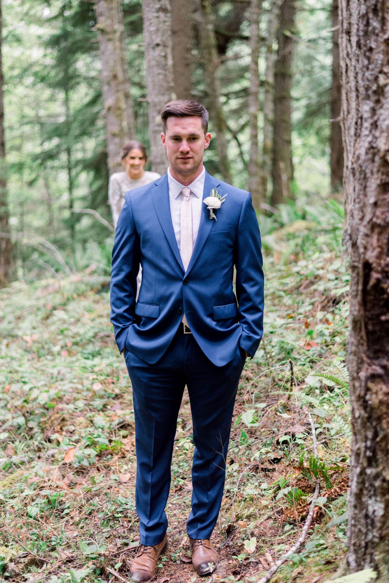 First look wedding moment captured in a peaceful forest setting.