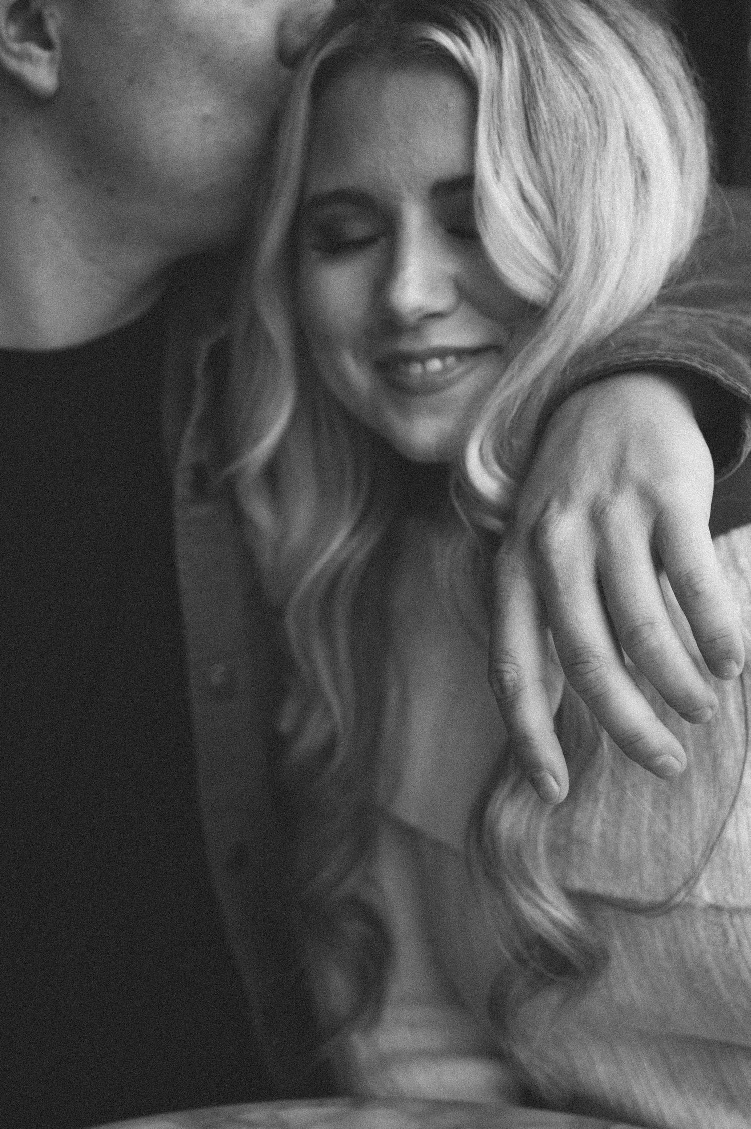 An intimate black and white portrait of a couple sharing a tender moment together.