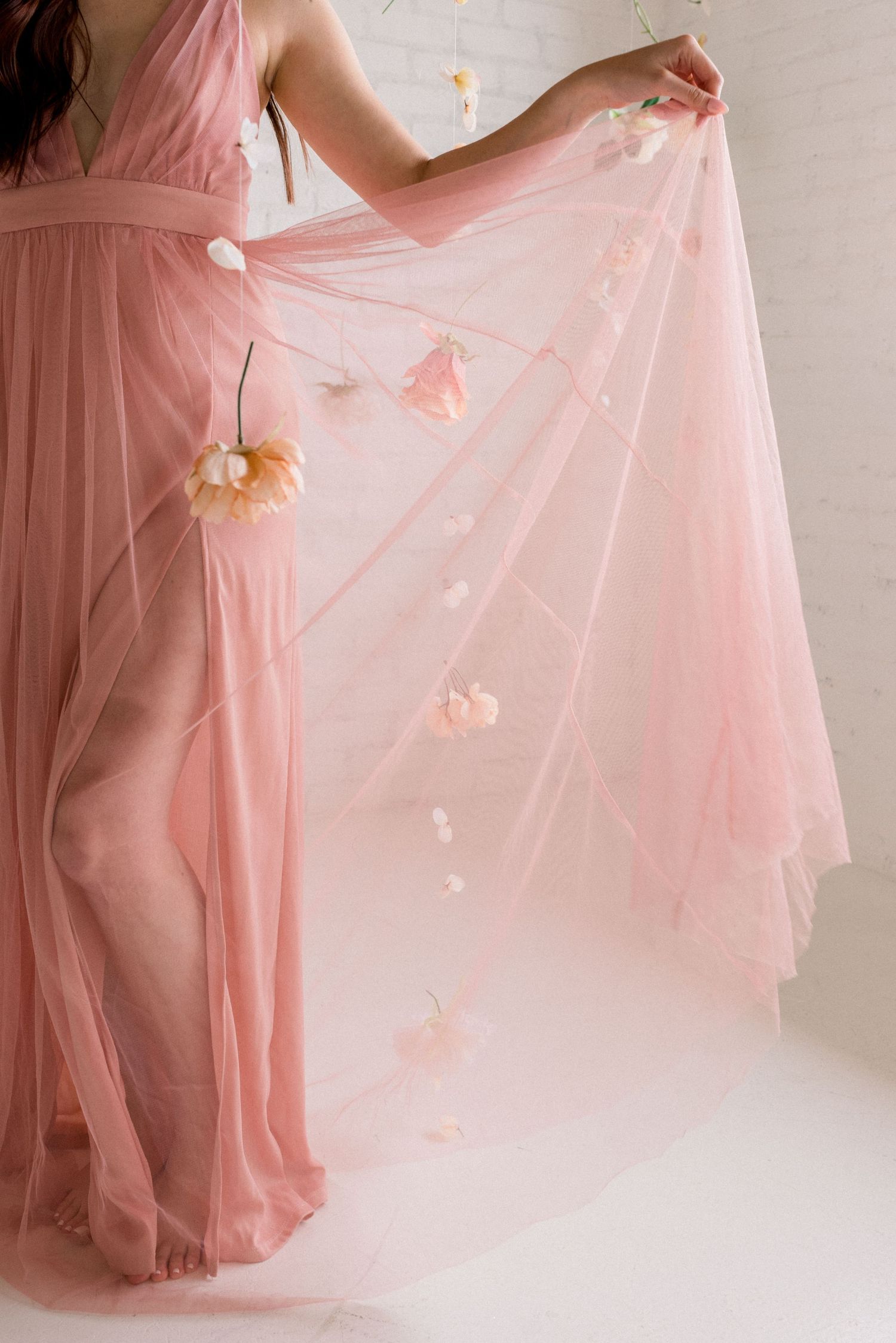 Pink flowy dress with delicate floral details and ethereal tulle fabric.