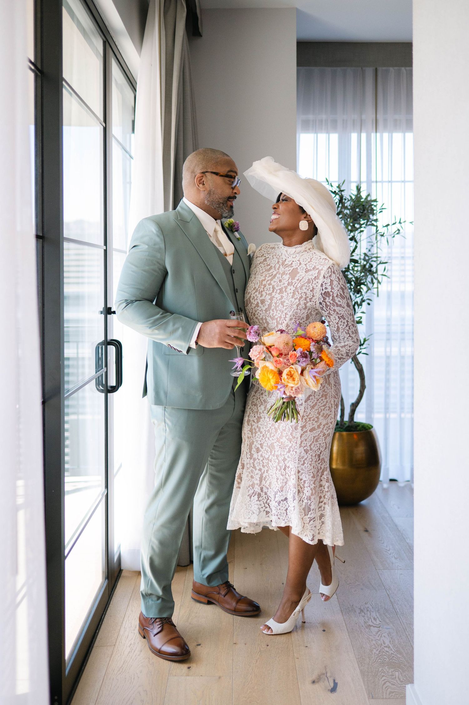 A couple in wedding attire sharing intimate moments in a modern, bright interior space.