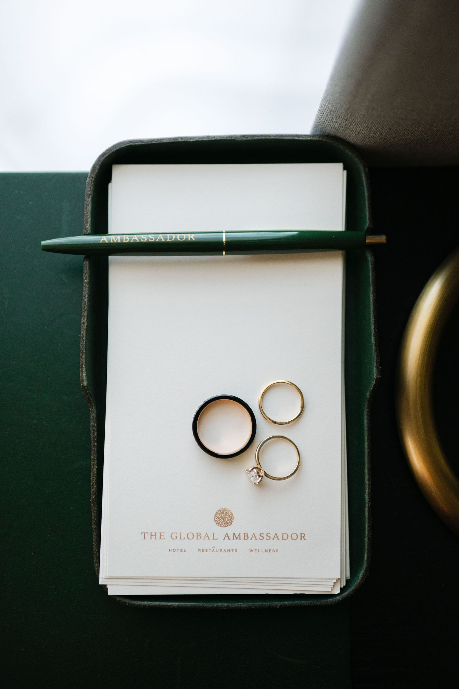 Wedding rings displayed in a sequence of four photos on white paper in a dark green box.