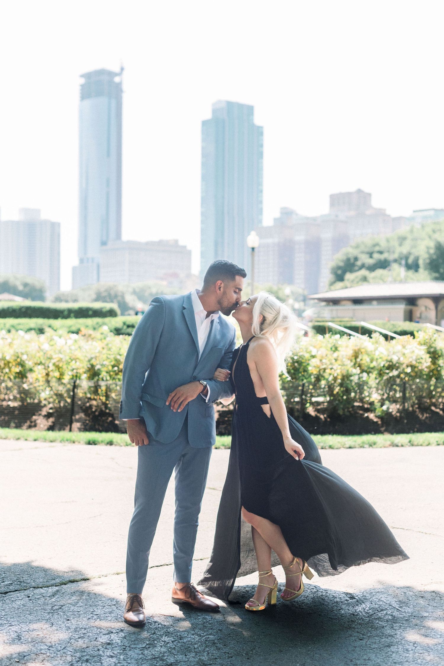 Stylish couple sharing an intimate moment with Chicago skyscrapers in the background.