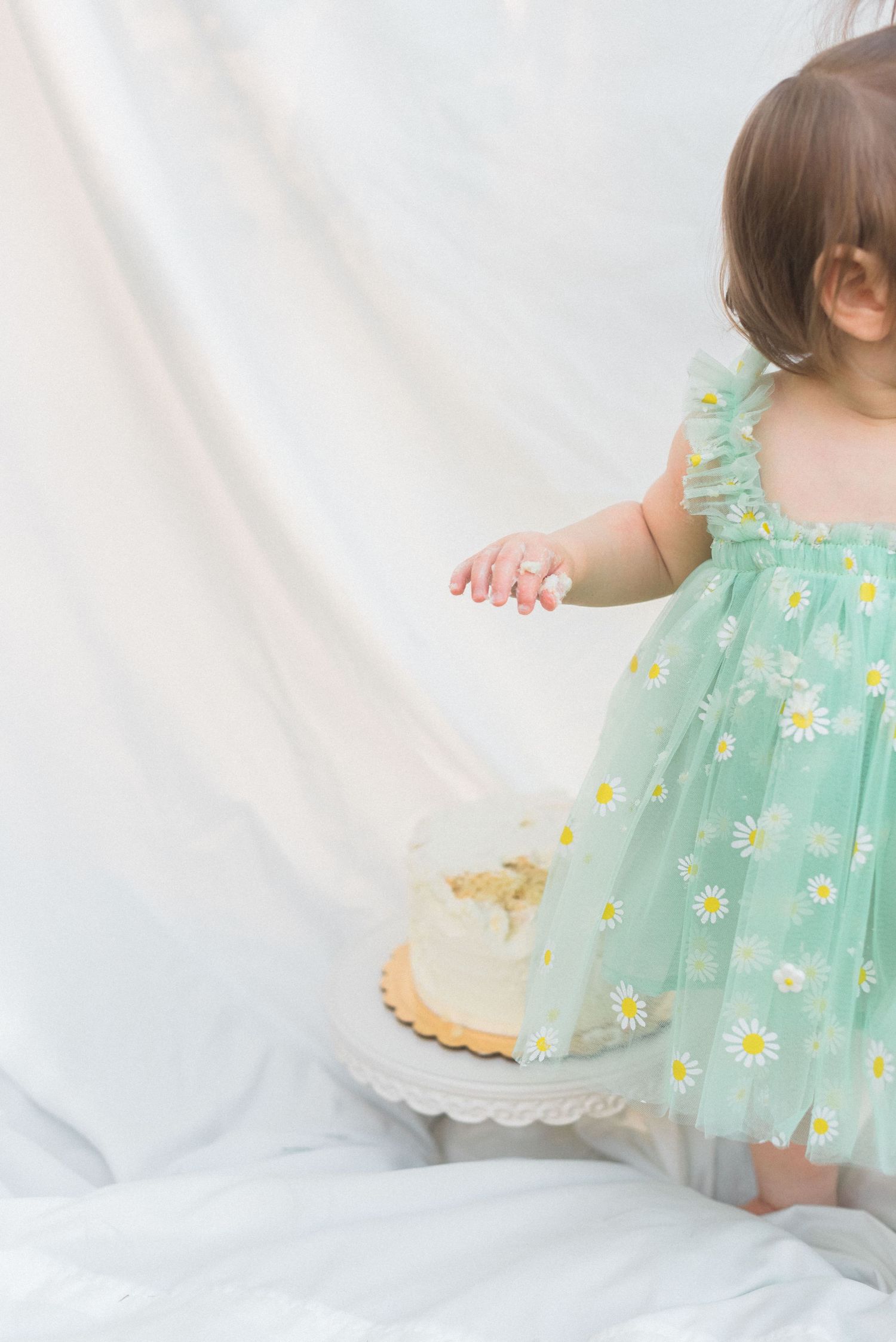 Mint green dress details against white backdrop in delicate lighting.