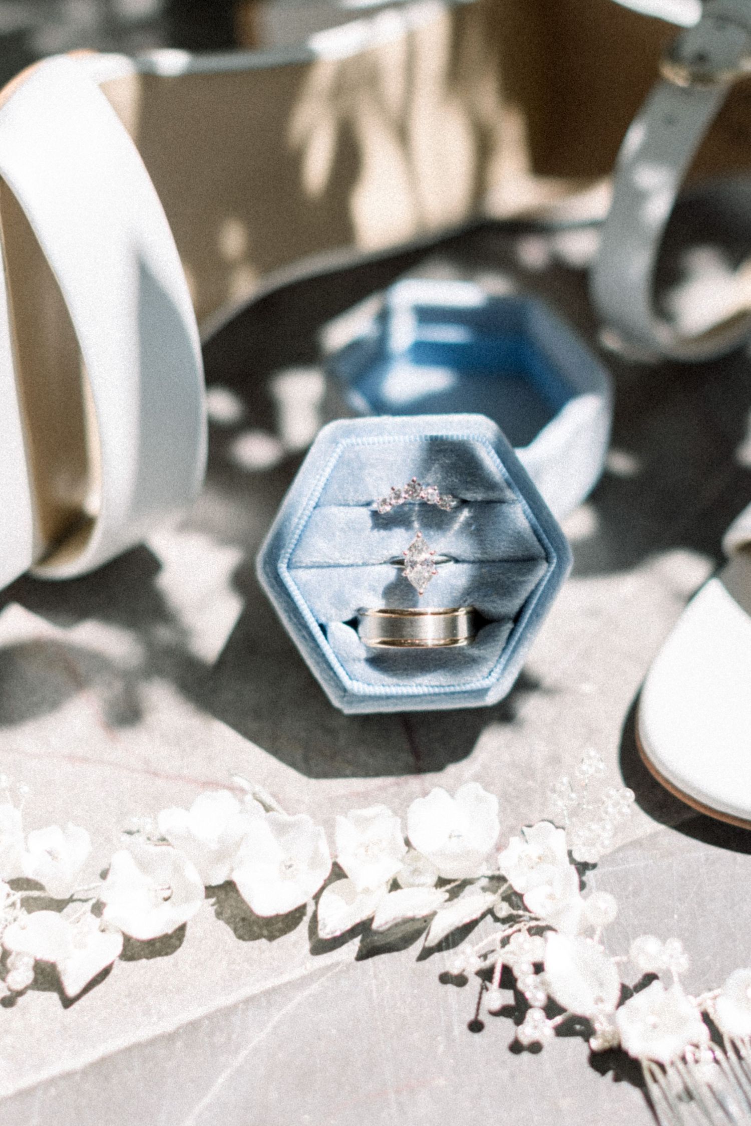 Wedding rings displayed in blue hexagonal ring box with soft shadows.