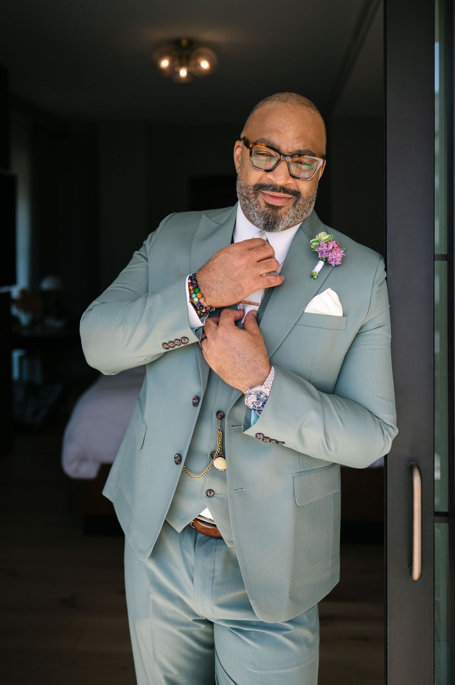 A person in a light gray suit strikes different poses while smiling and gesturing in a photo series.