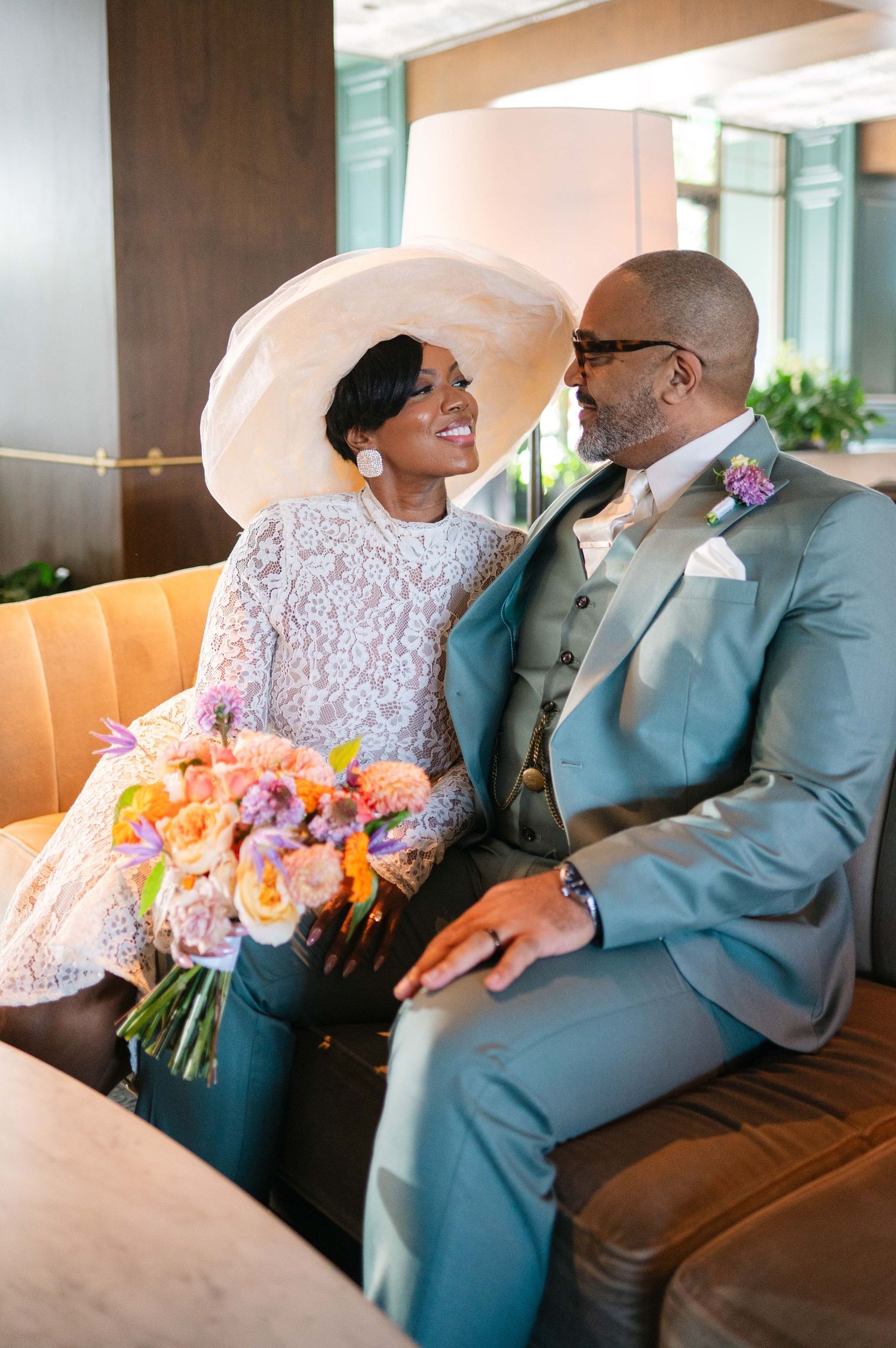 A couple sharing intimate moments while sitting on a couch in a modern indoor setting.