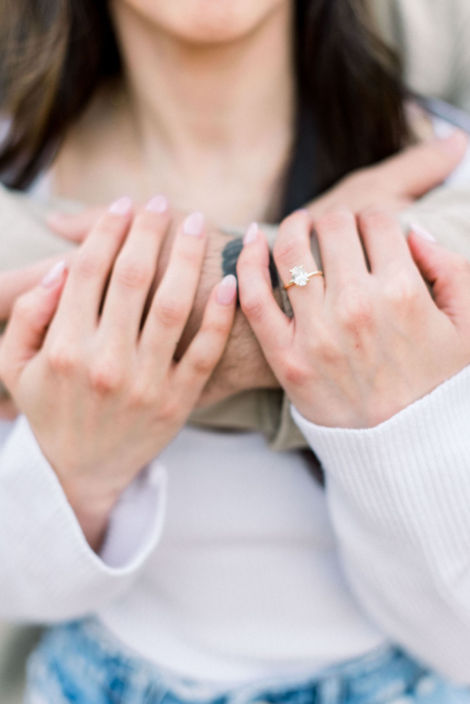 A series of hands showing off a sparkling engagement ring in different angles and poses against a light background.