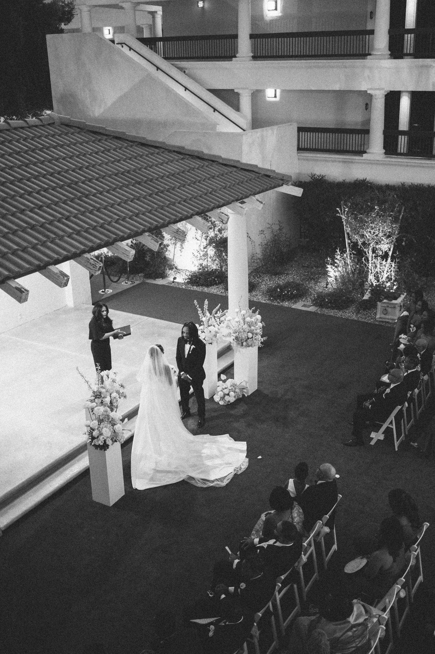 Wedding reception setup at night with string lights illuminating an outdoor patio area.