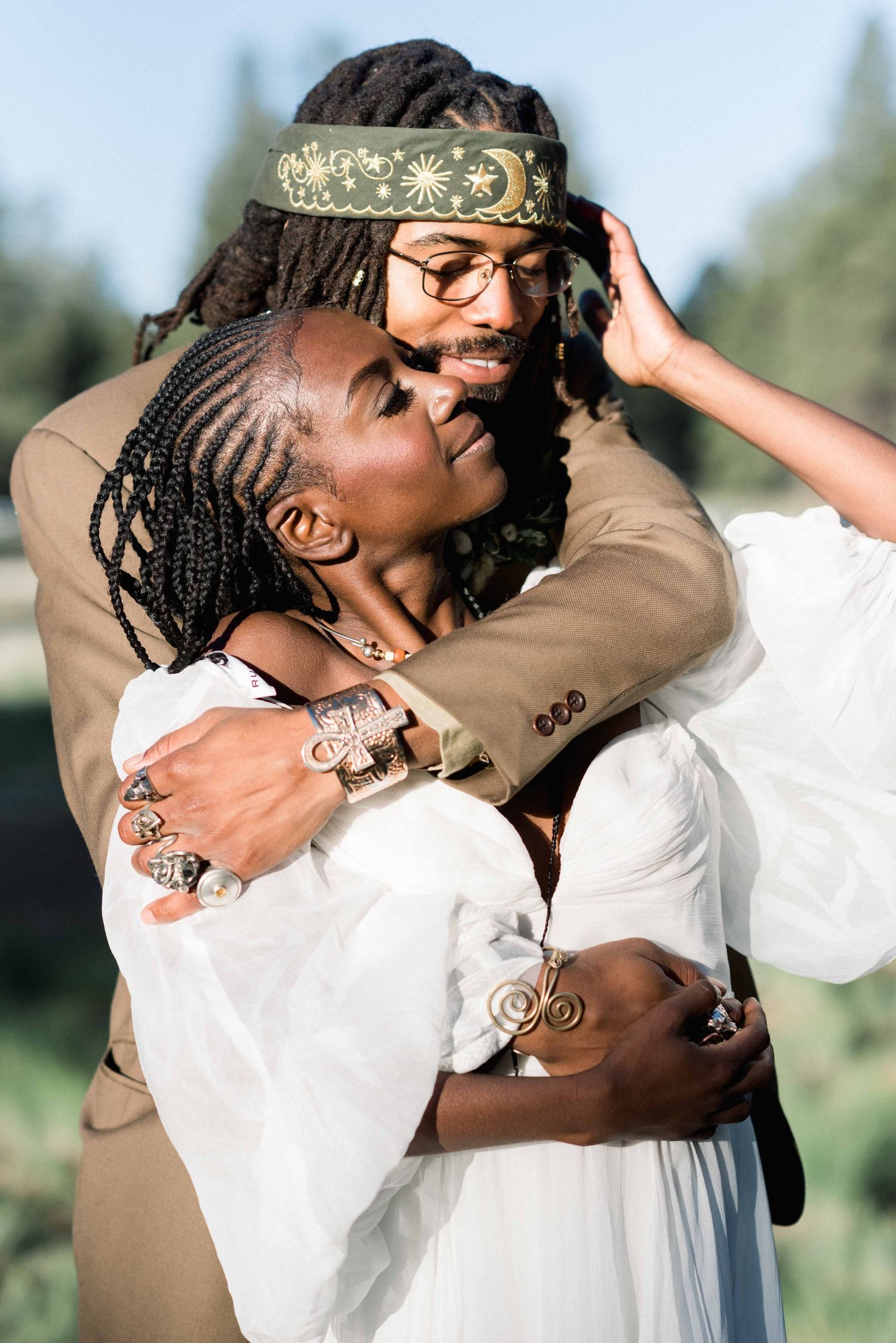 Tender moment between newlyweds in a sunlit outdoor setting.
