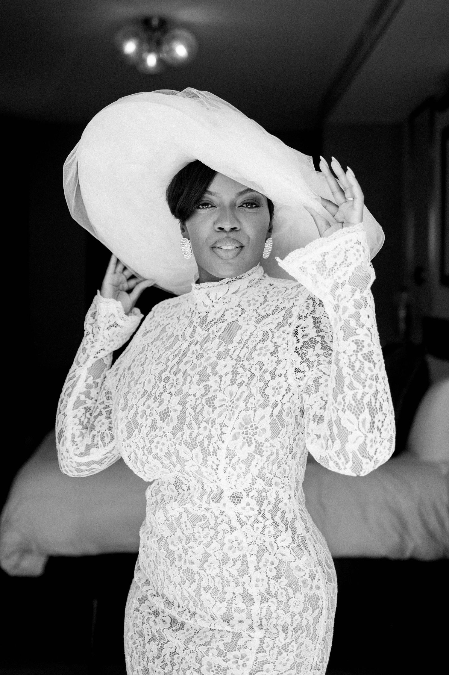 A series of dramatic black and white portraits featuring someone wearing an elegant white lace top and hat.