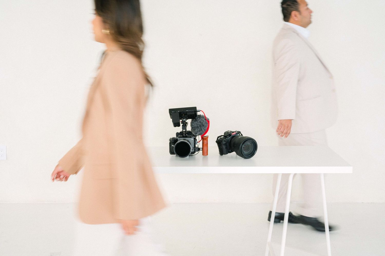 Studio photography setup with light colored outfits and professional camera equipment.