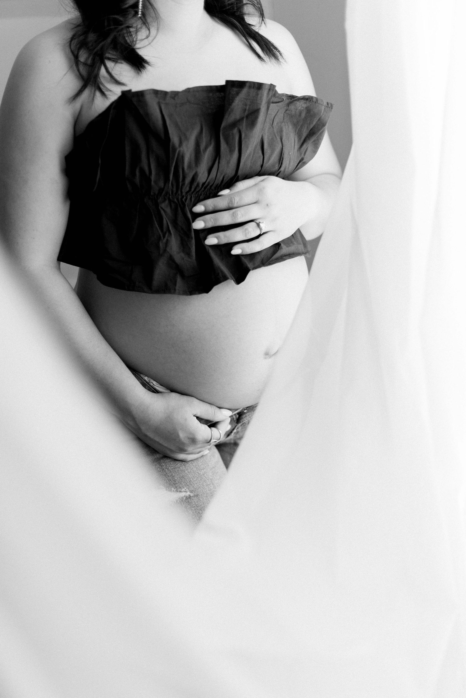 Artistic black and white maternity photo with woman wearing black top.