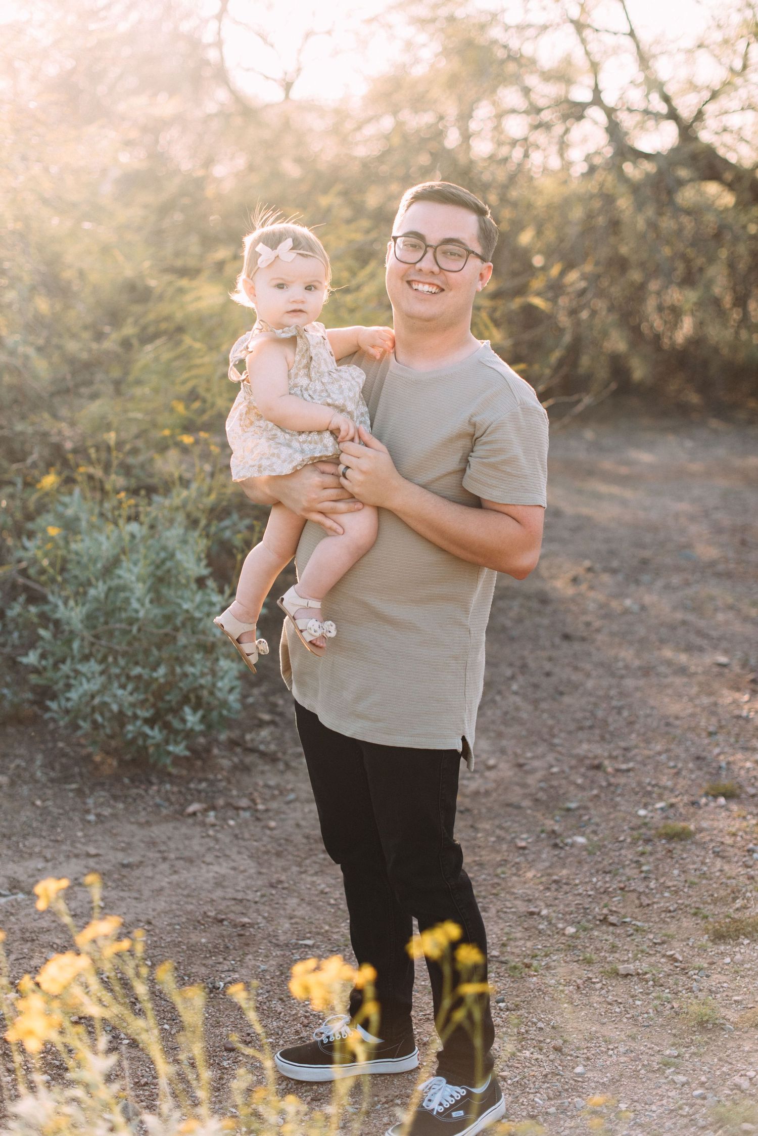 Parent and child share sweet moment together on desert trail with yellow wildflowers.