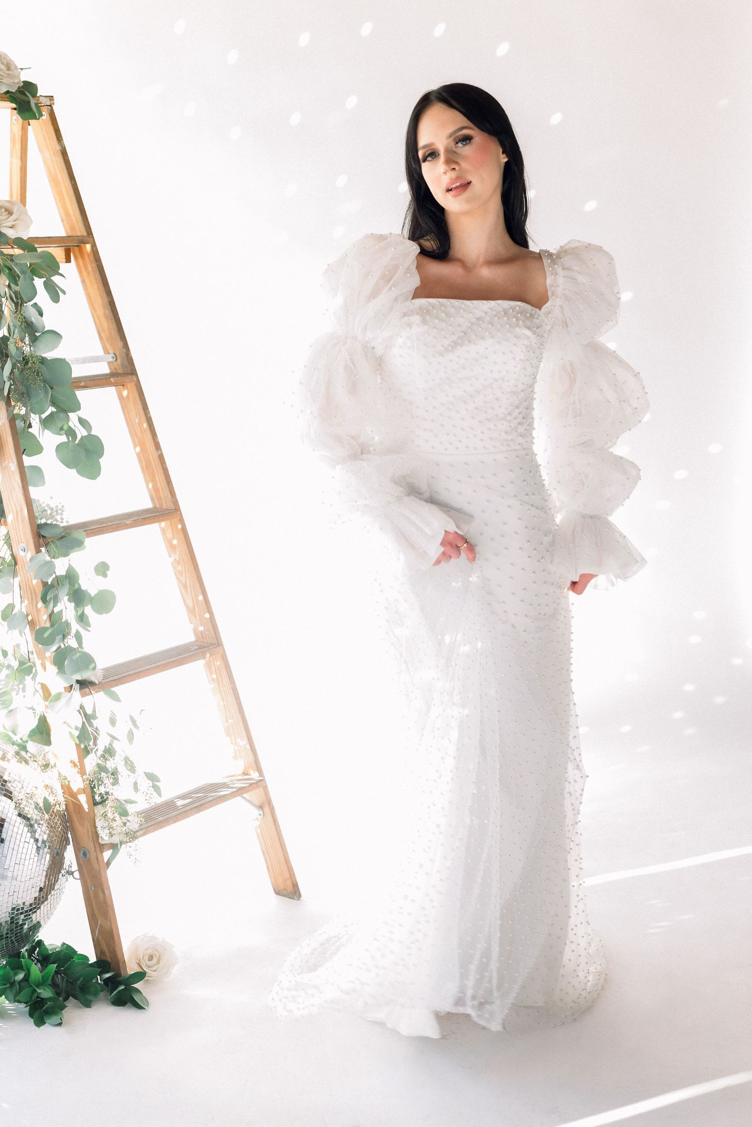 Wedding dress with dramatic puff sleeves against white background.