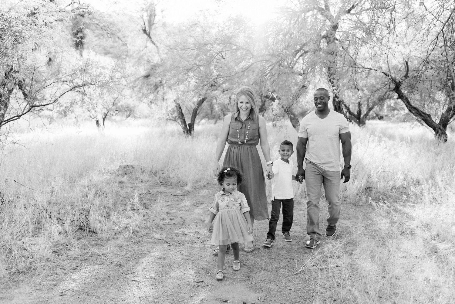 Black and white photo sequence showing a group walking along a path through trees in a natural outdoor setting.