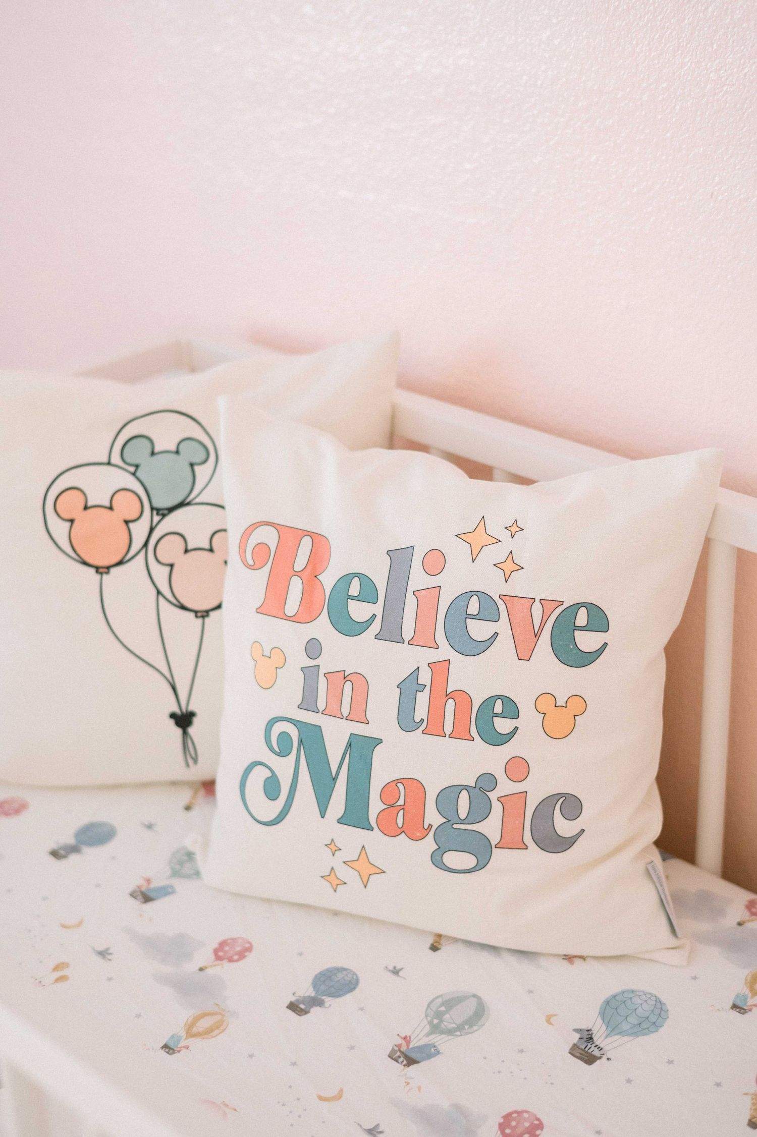 Disney-themed throw pillow with 'Believe in the Magic' text in pastel colors.