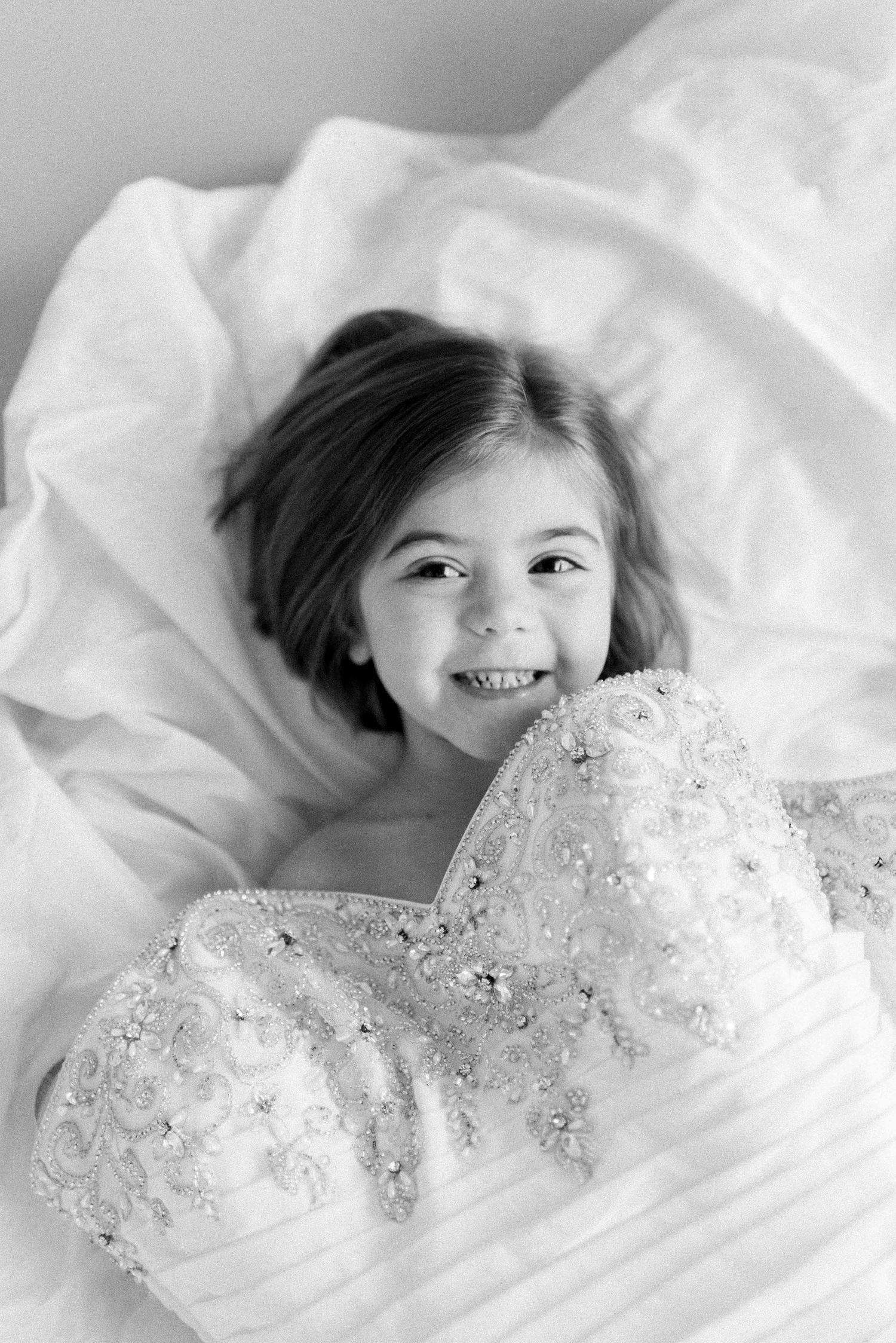 Sweet black and white portrait showcasing genuine happiness surrounded by white linens.