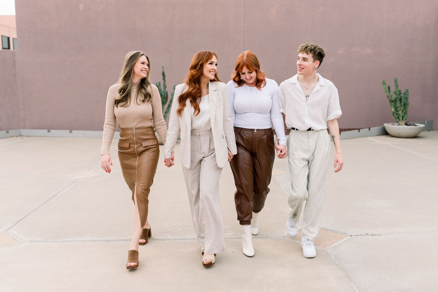 Group walking together in stylish earth-tone clothing against an urban backdrop.