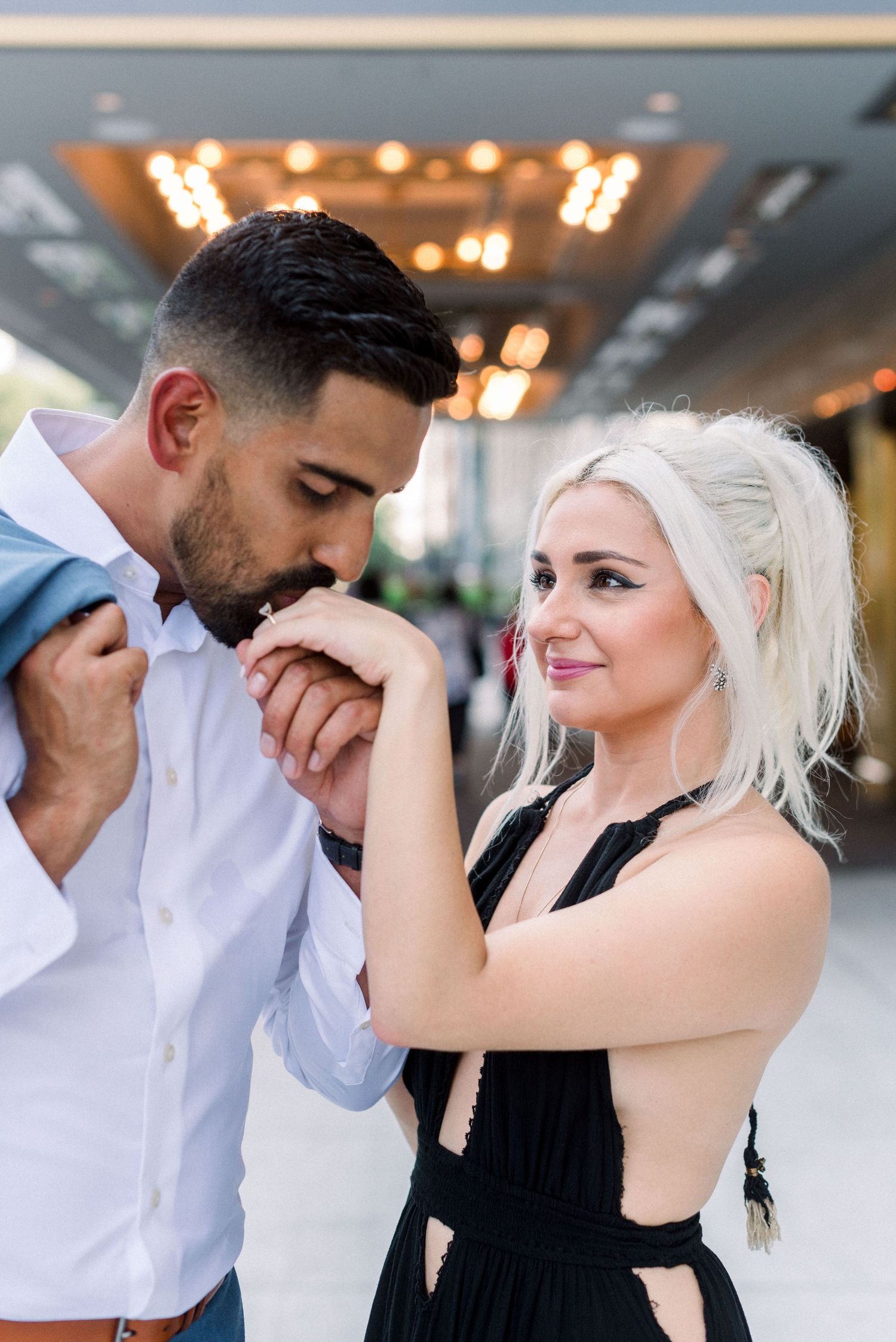 Romantic couple shares intimate moment under hotel lighting.