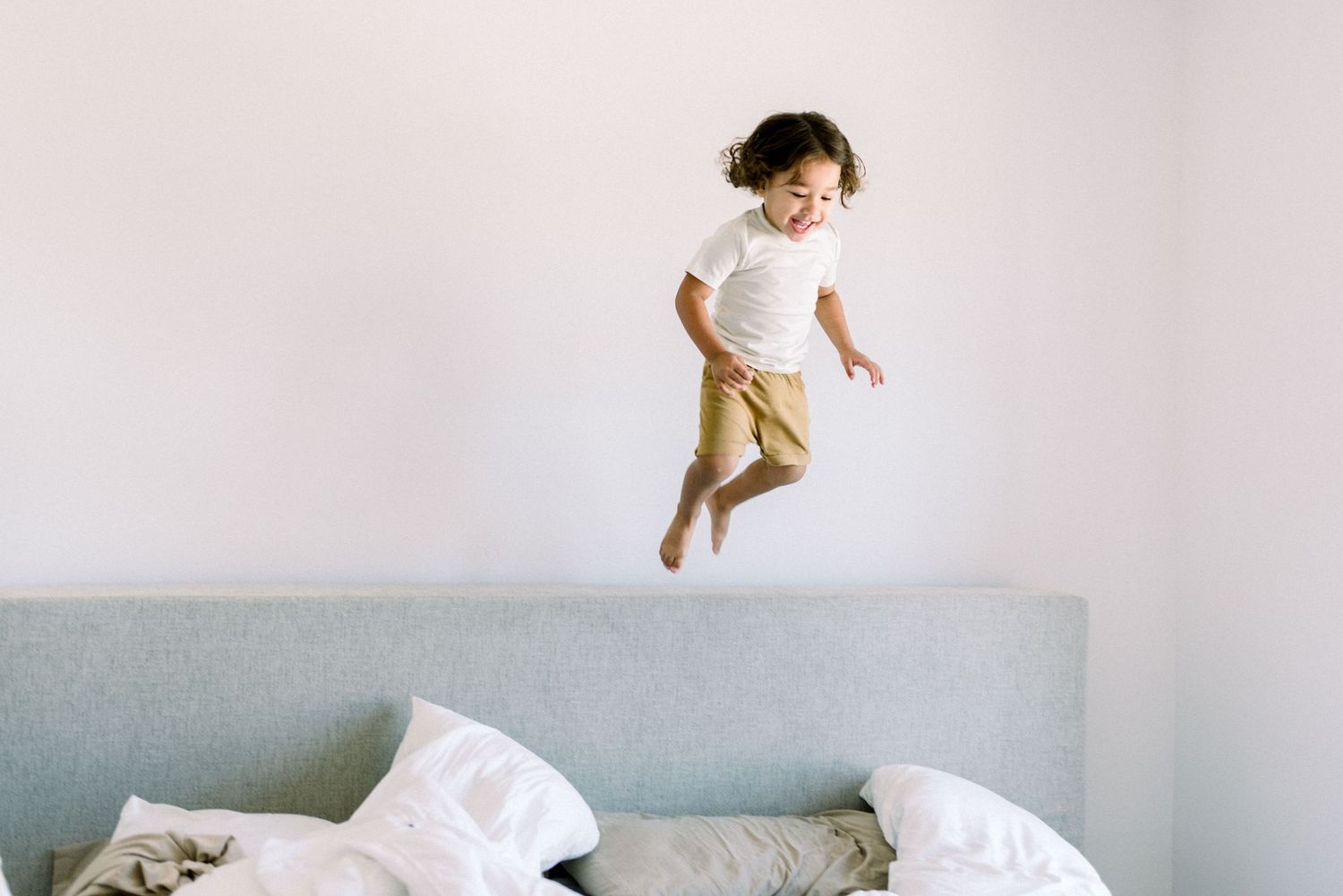 cute little boy jumping off bed